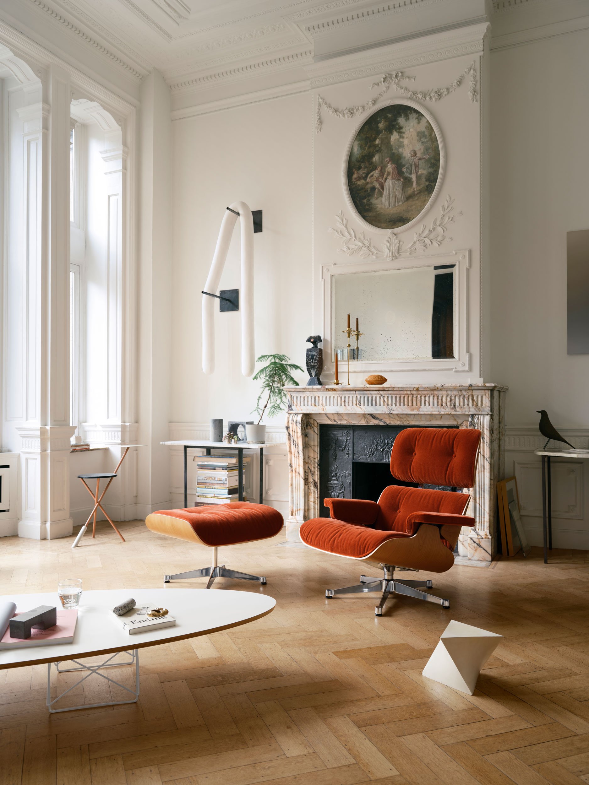 Home Stories for Winter 25 wurden beim Architekten David Van Severen und der Modefotografin Martina Bjorn fotografiert. Neuer Lounge Chair in Stoff mit weissem Eames- Elliptical Table vor Cheminée.
