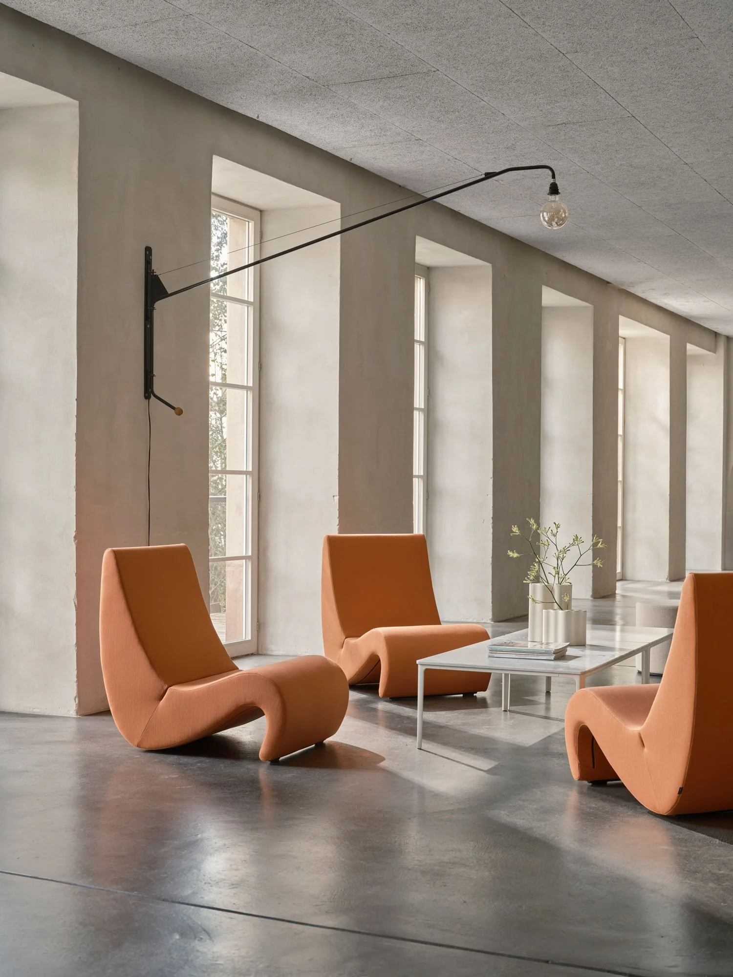 Jugendherberge Basel, Eingangsbereich mit drei Panton Sesseln (Amoebe) und einem Marmor Couchtisch. An der Wand hängt eine Potence Leuchte 