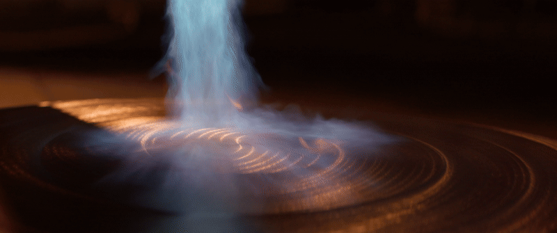 A woman using a flame torch as part of the gong-making process.