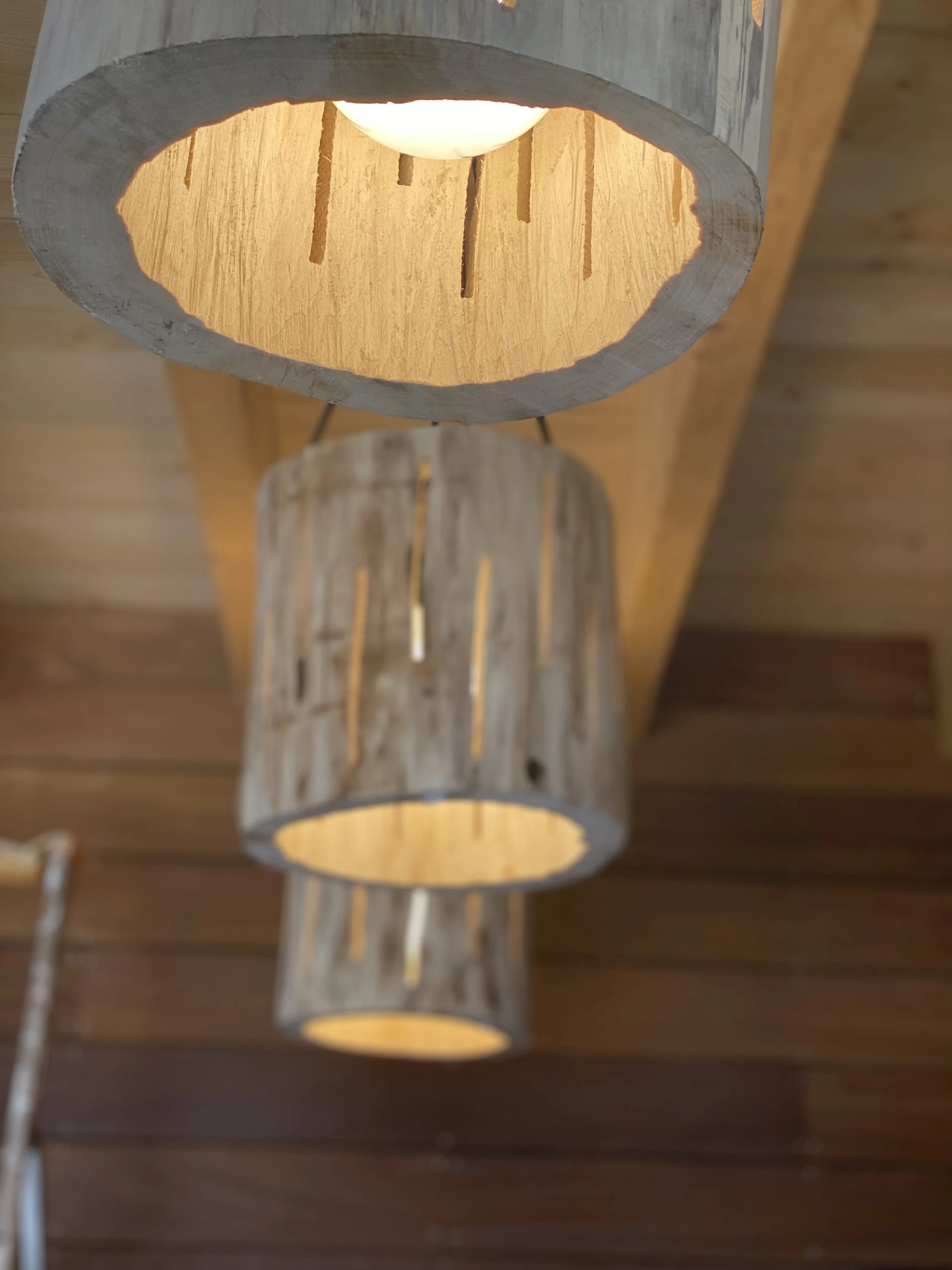 Suspension lumineuse en bois avec trois abat-jours.