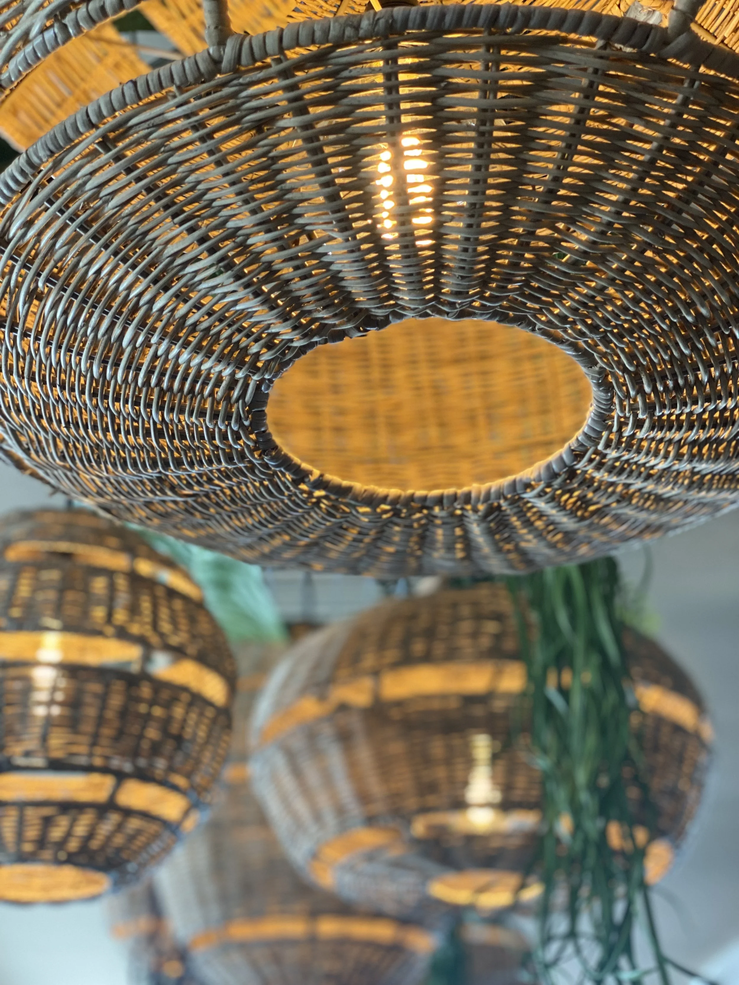 Suspensions en rotin tressé avec des lumières allumées.
