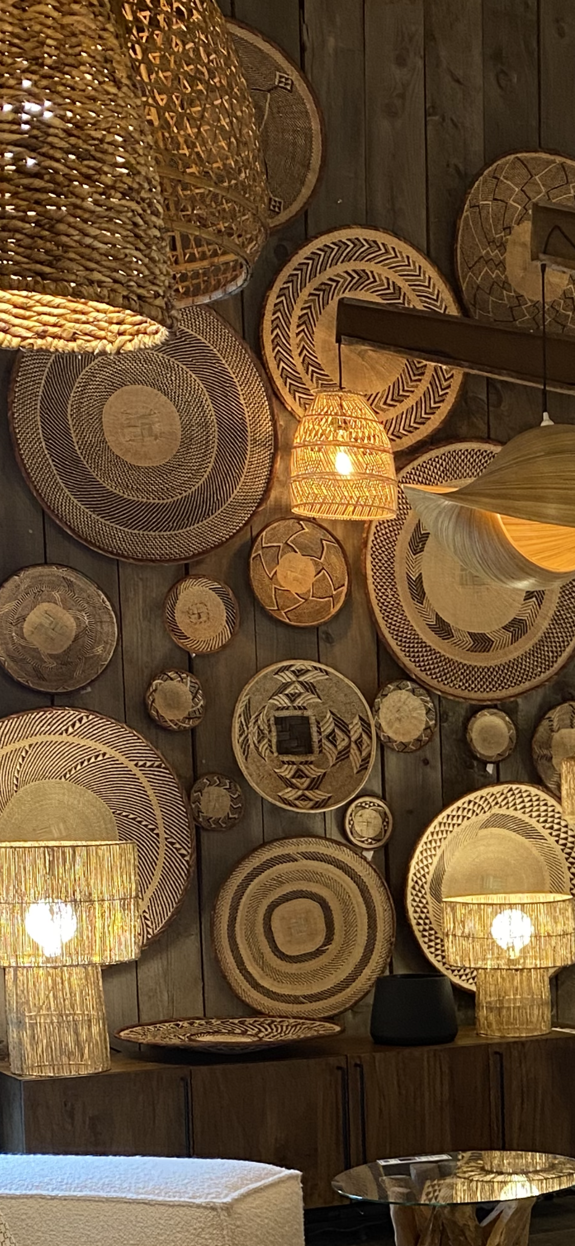 Décoration murale avec des paniers tressés et luminaires en osier.