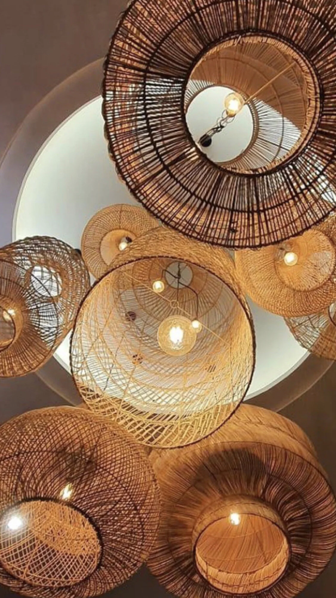 Lustres en rotin suspendus avec des ampoules visibles, design moderne.