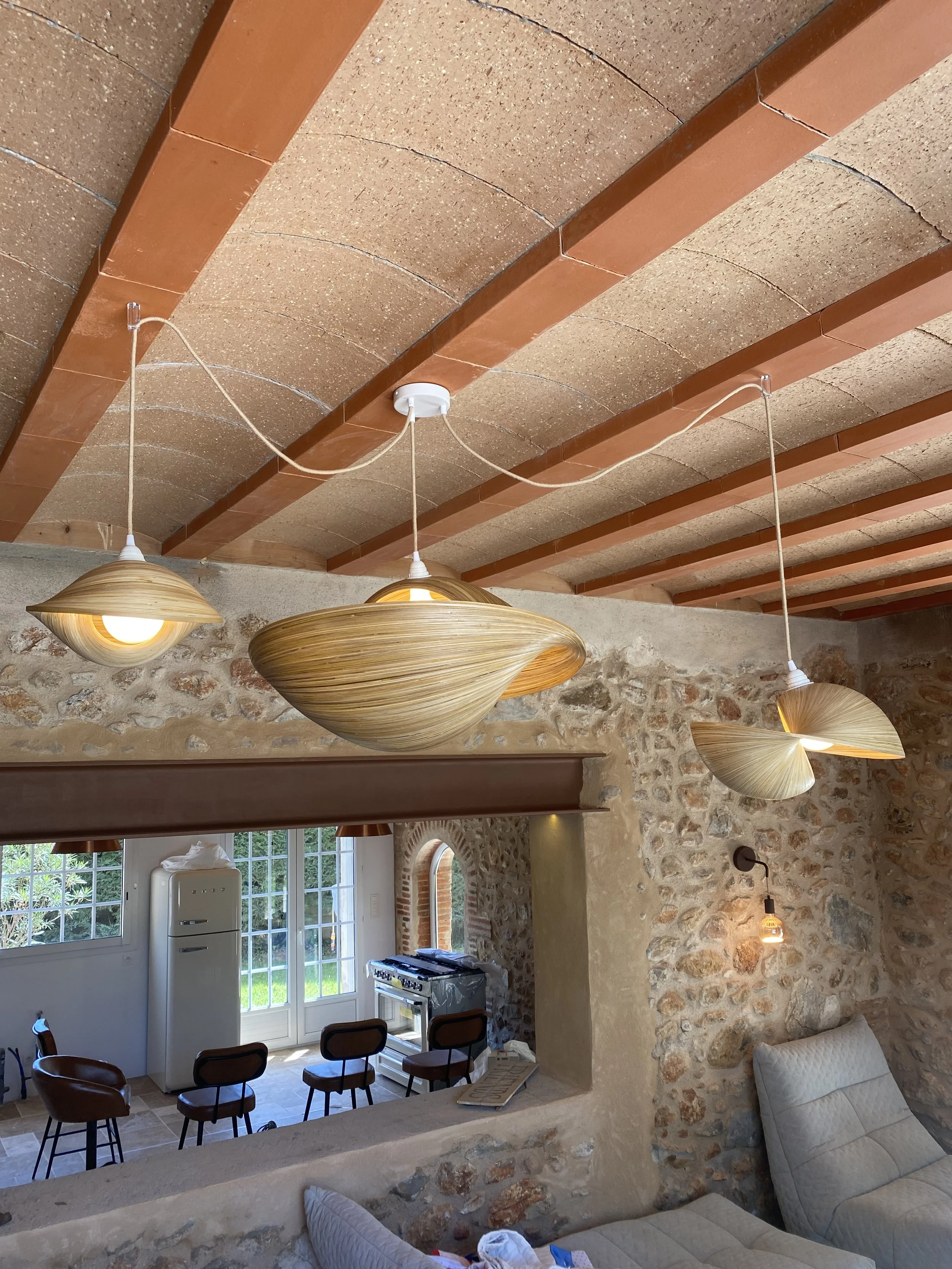 Intérieur avec plafonniers modernes, murs en pierre, et meubles