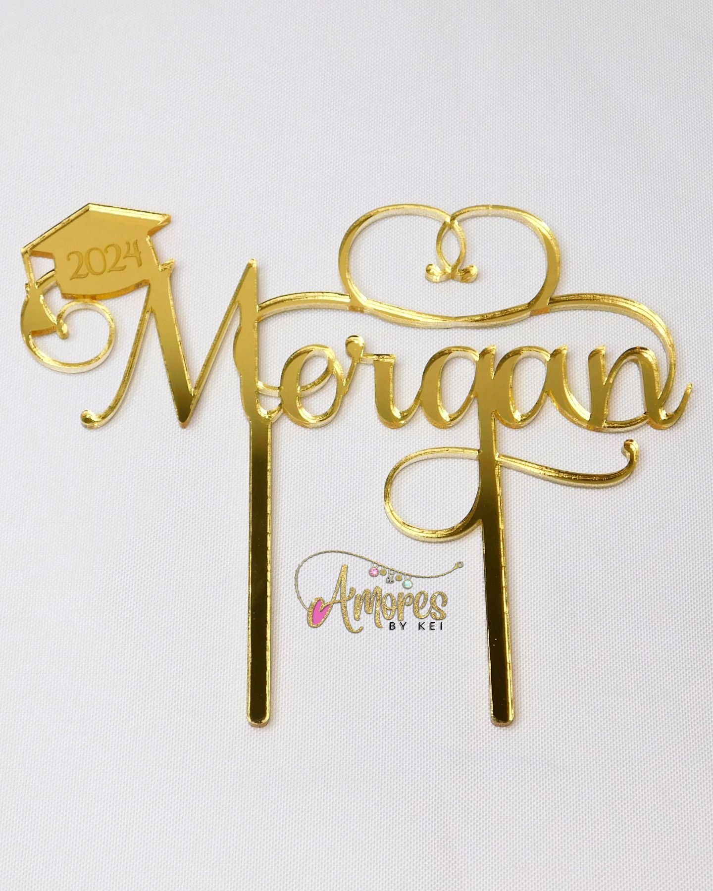 I am accepting orders for Graduation Cake Toppers! The design is like on the pictures; name and graduation cap om first letter with year 2024 engraved on it.

Tails and swashes on this font all vary by letter and name, a mockup is always sent after I