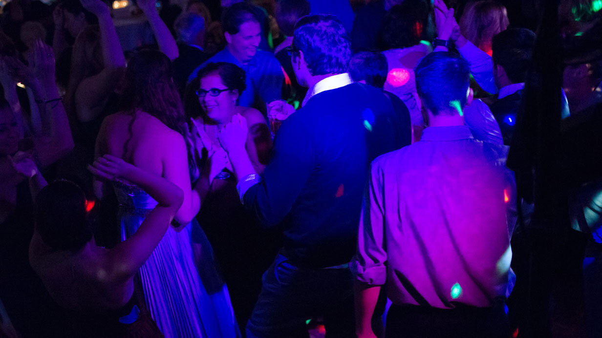 People dancing at a lively nightclub with colorful lights.