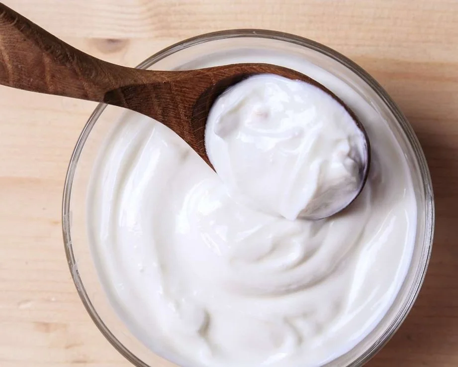 bowl of homemade yoghurt with a wooden spoon
