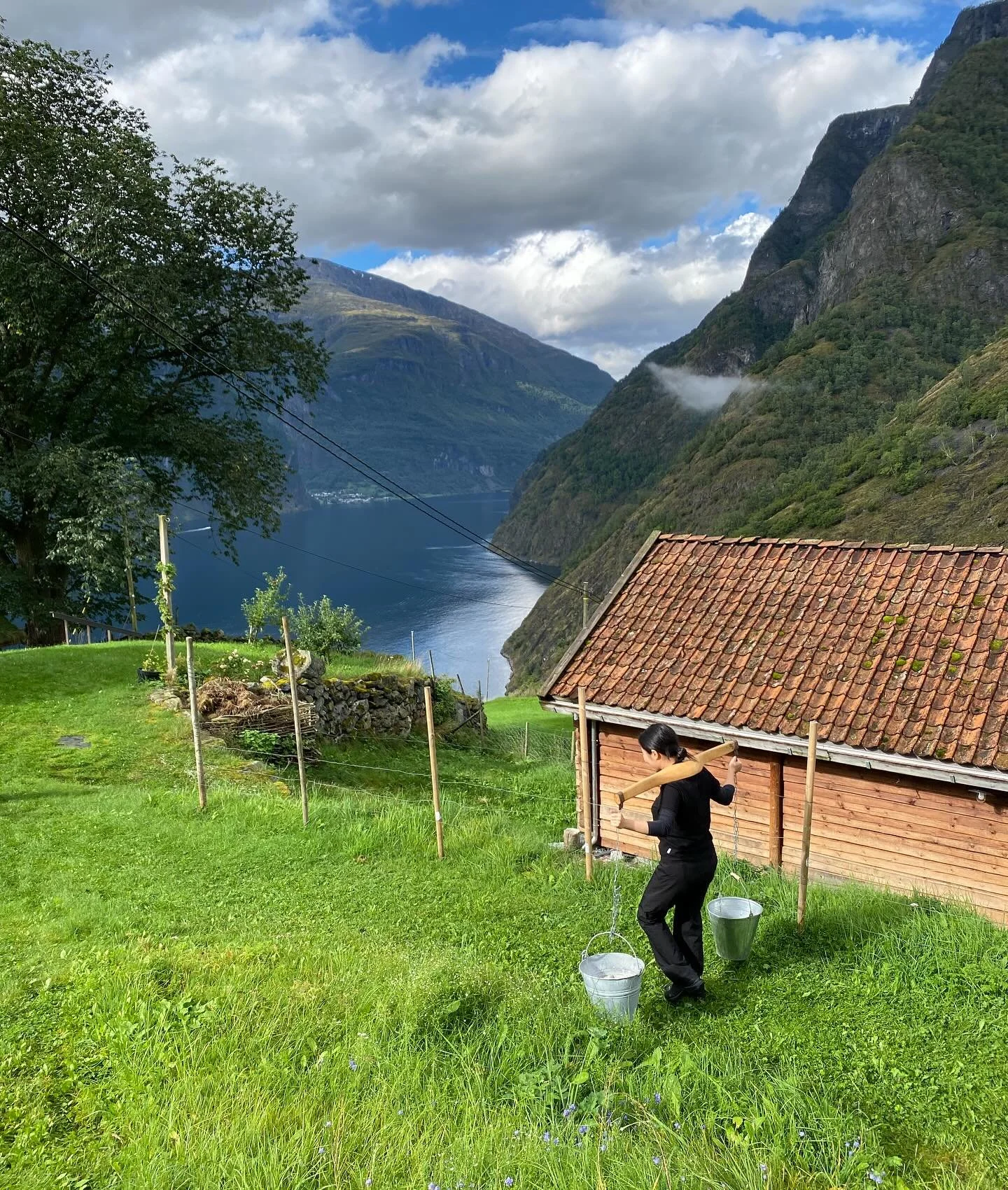 Elev ved Fana folkehøgskule som bærer vann til en hytte ved hardangerfjorden