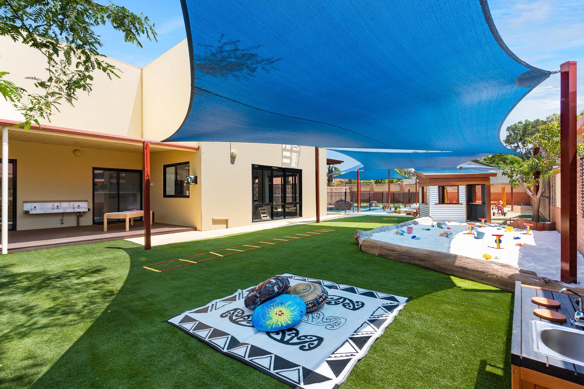 Outdoor grass area at Cuddles Childcare Canning Vale showing the sandpit