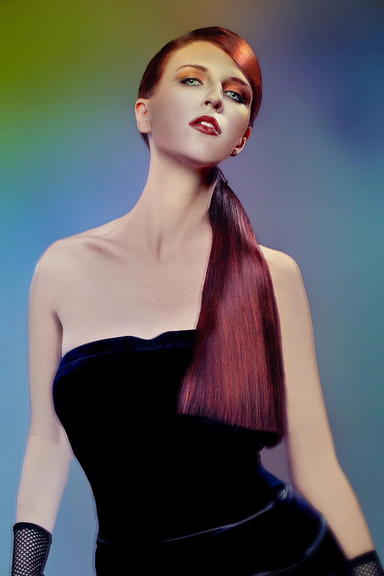 A woman with red hair styled in loose waves, wearing a strapless black dress, gold eye makeup, red lipstick, fishnet gloves, and striking a confident pose against a multicolored background. Best-Fashion-Portrait-Commercial-Business-Headshots-Corporat