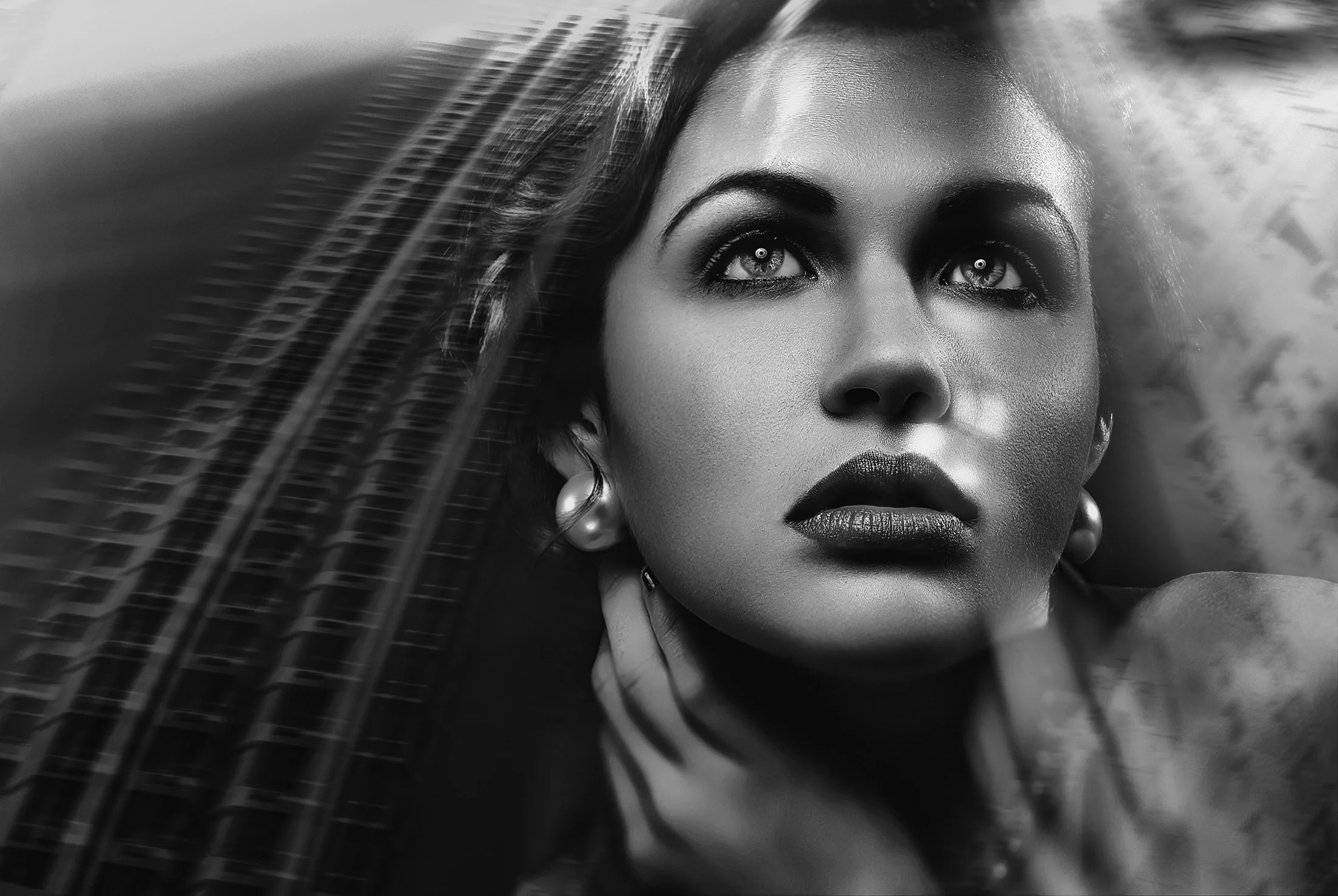 Black and white close-up portrait of a woman with striking eyes, dark lips, and earrings, with hair flowing and a contemplative expression. Dynamic fashion branding and portrait photography by www.exvotostudio.com located in Maryland U.S.A. 