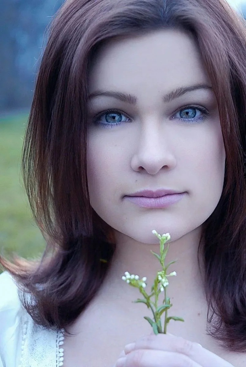 A young woman with blue eyes and shoulder-length brown hair holding a small white flower in front of her chest. Best-Fashion-Portrait-Commercial-Business-Headshots-Corporate- photography-Maryland-Washington D.C.-Pennsylvania-Virginia