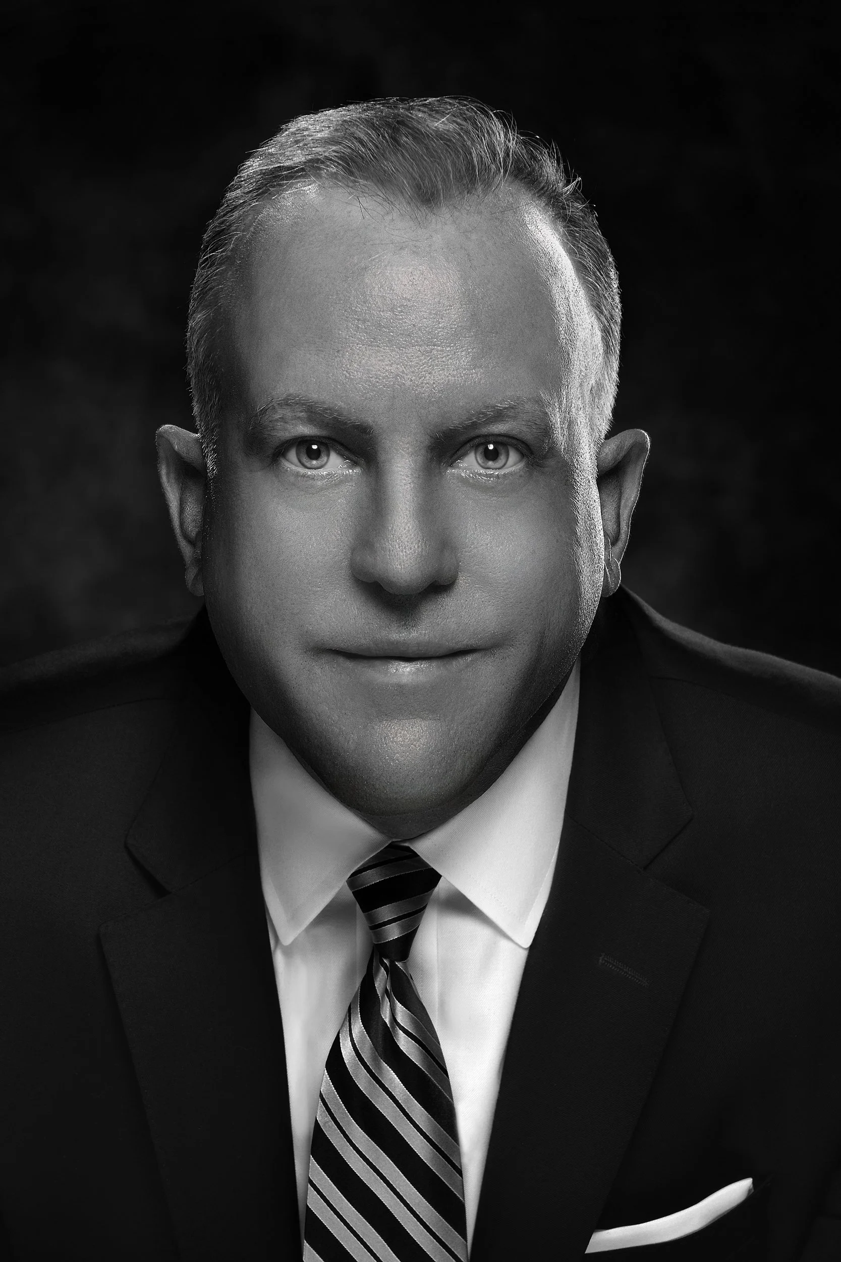 Black and white portrait of a man in a suit and tie, with short hair and light-colored eyes, looking directly at the camera. Edward Nemec New York Life Best-Fashion-Portrait-Commercial-Business-Headshots-Corporate- photography-Maryland-Washington D.C