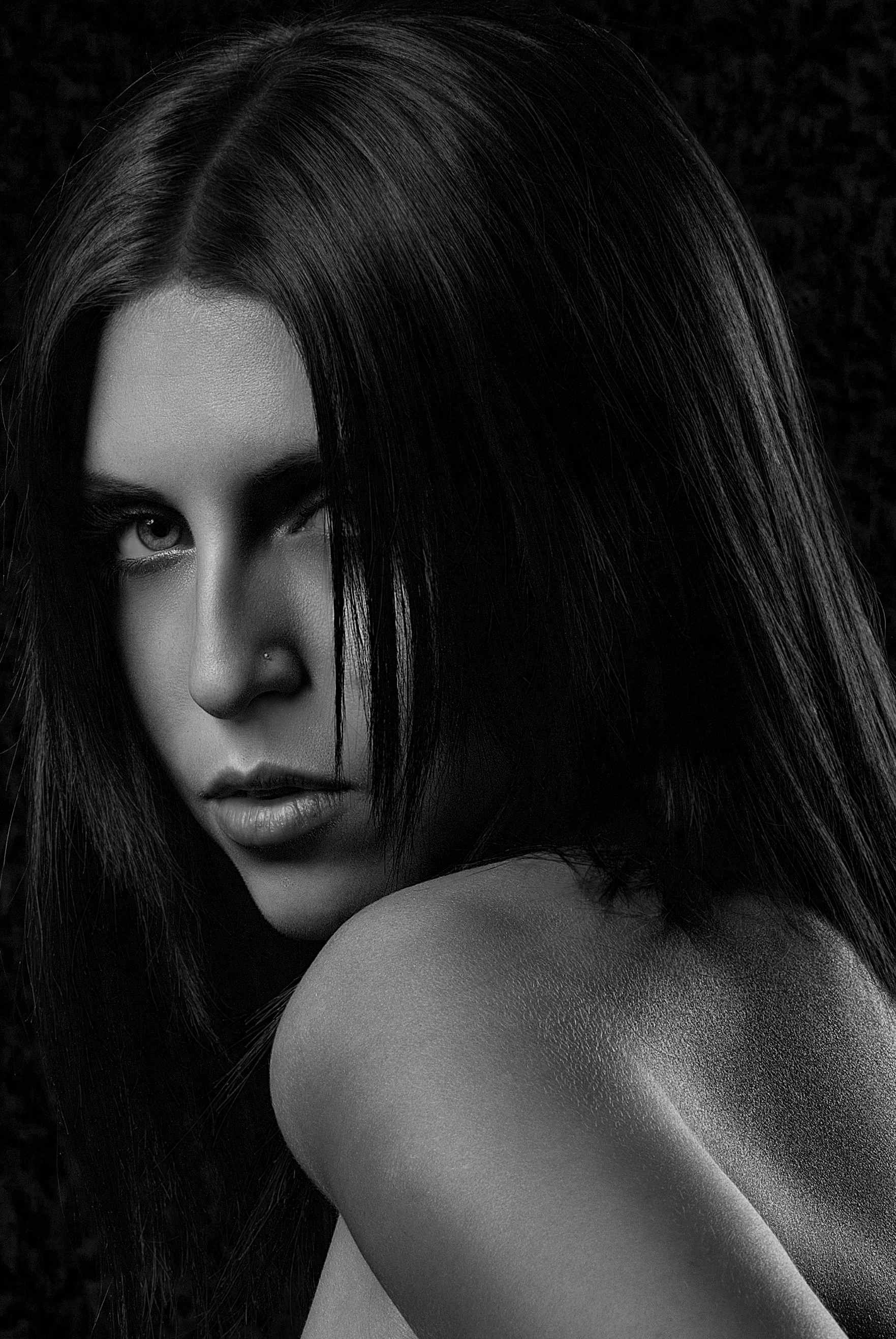 Black and white portrait of a woman with long, dark hair, looking over her shoulder with a serious expression. Best-Fashion-Portrait-Commercial-Business-Headshots-Corporate- photography-Maryland-Washington D.C.-Pennsylvania-Virginia
