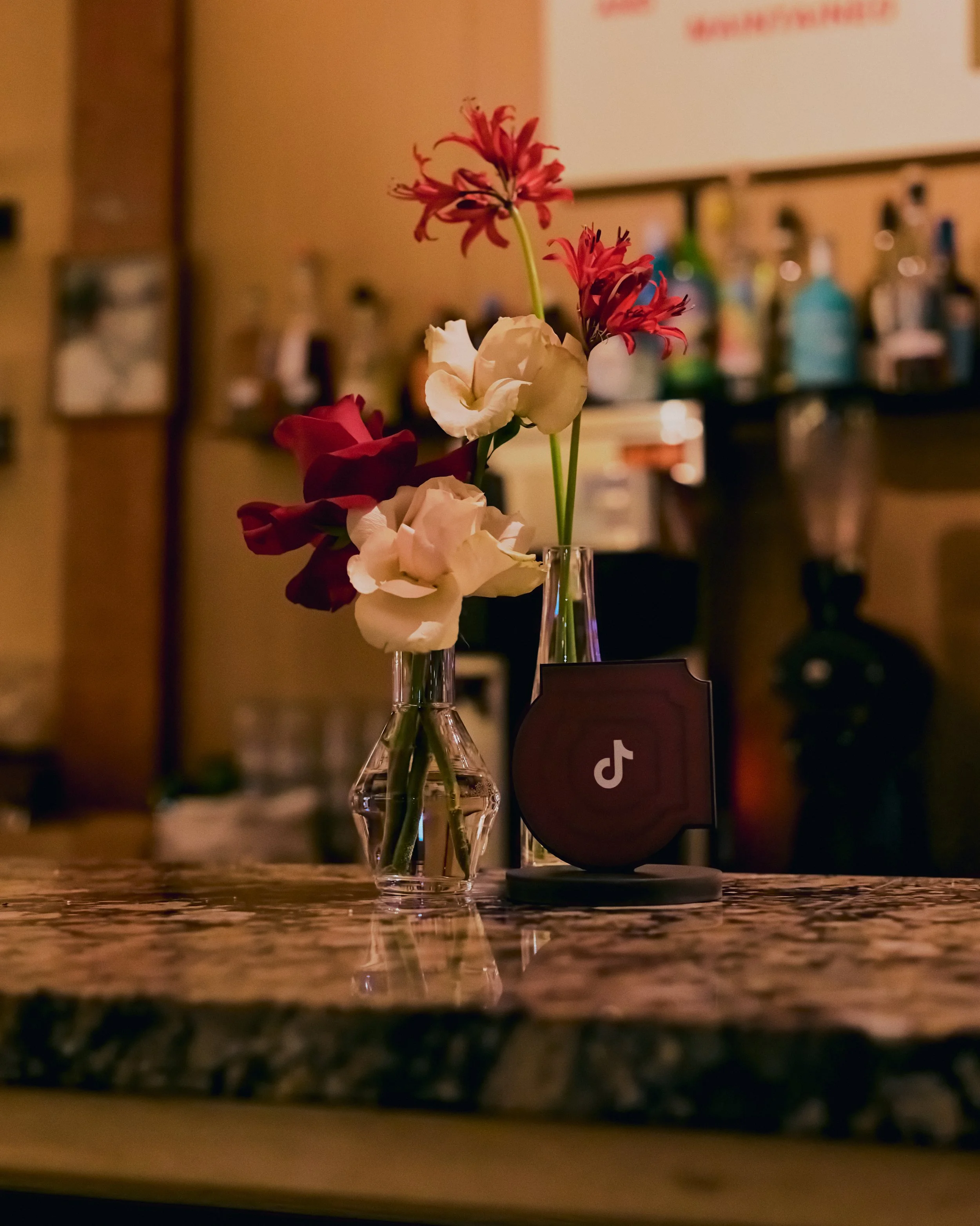 A bud vase with nude and red flowers for the Tik tok event at GIA