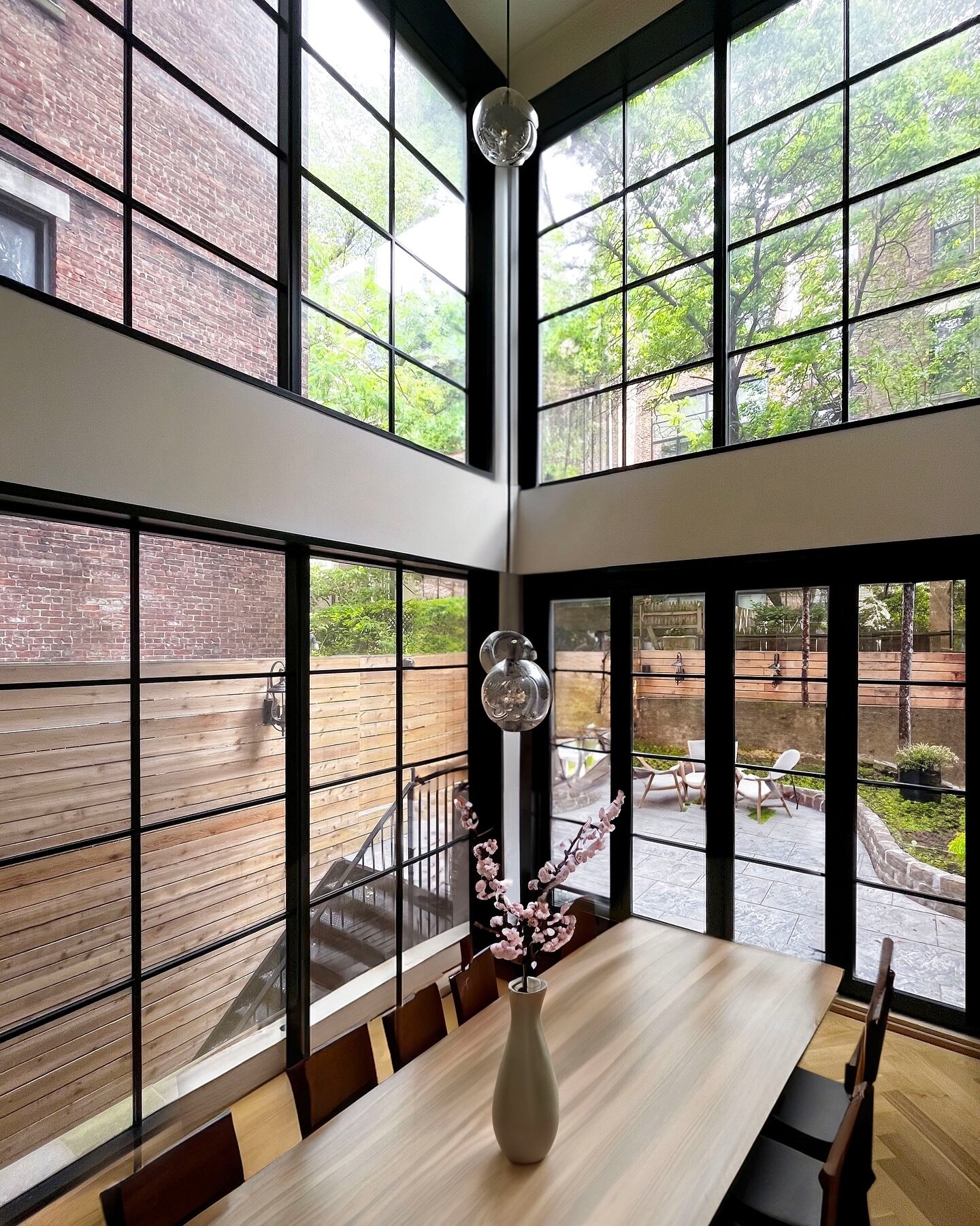 This new dramatic double-height dining space is the centerpiece of the landmarked, 6 story Upper West Side NY townhouse. The 20-ft tall, floor-to-ceiling windows visually connect the indoor and outdoor, and bring the so much needed day-light into the