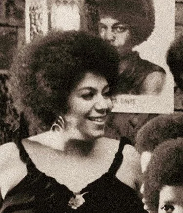 Regina Jones smiling beside a poster.