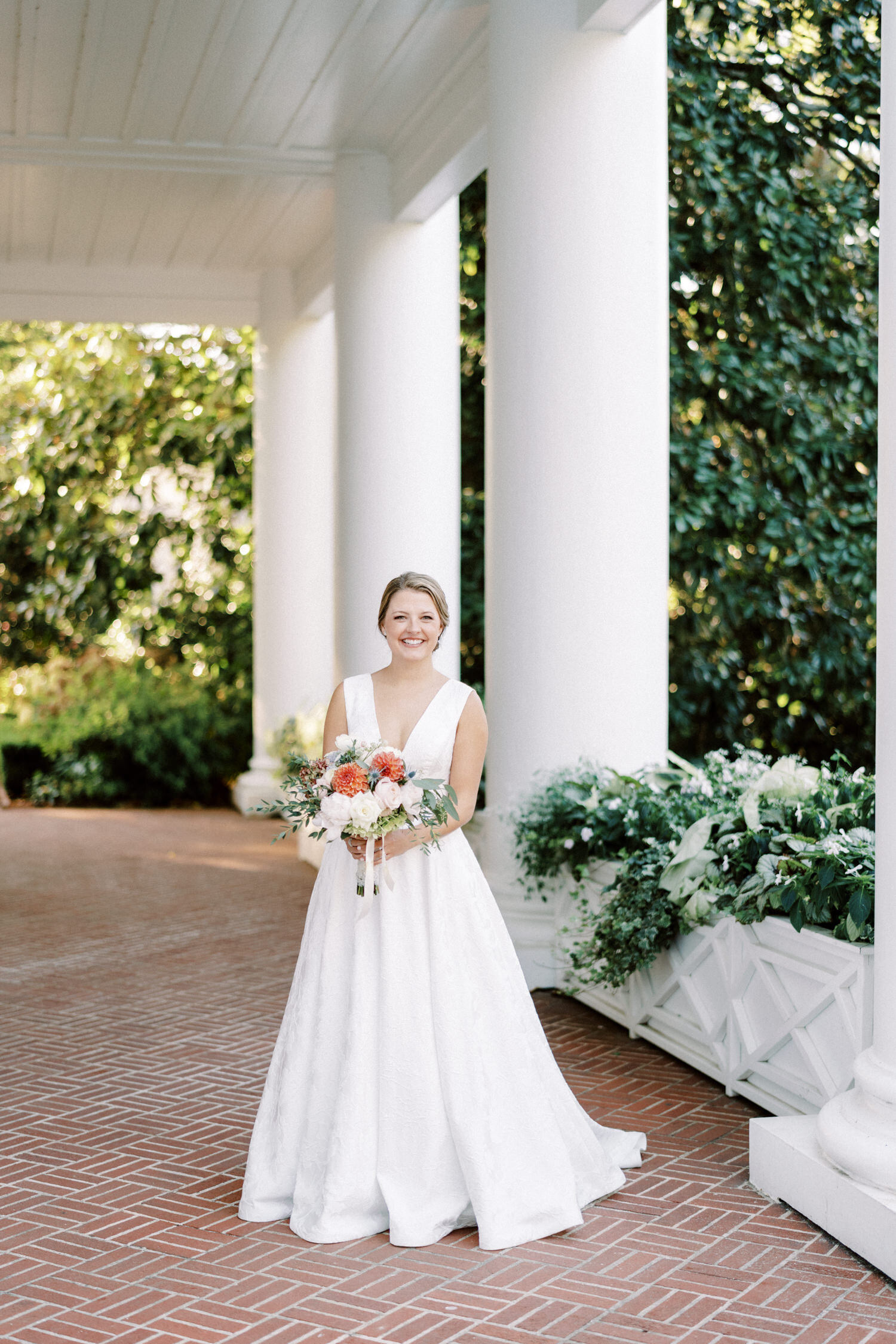 A happy bride posing on the front porch of The Duke Mansion, Charlotte, NC. 