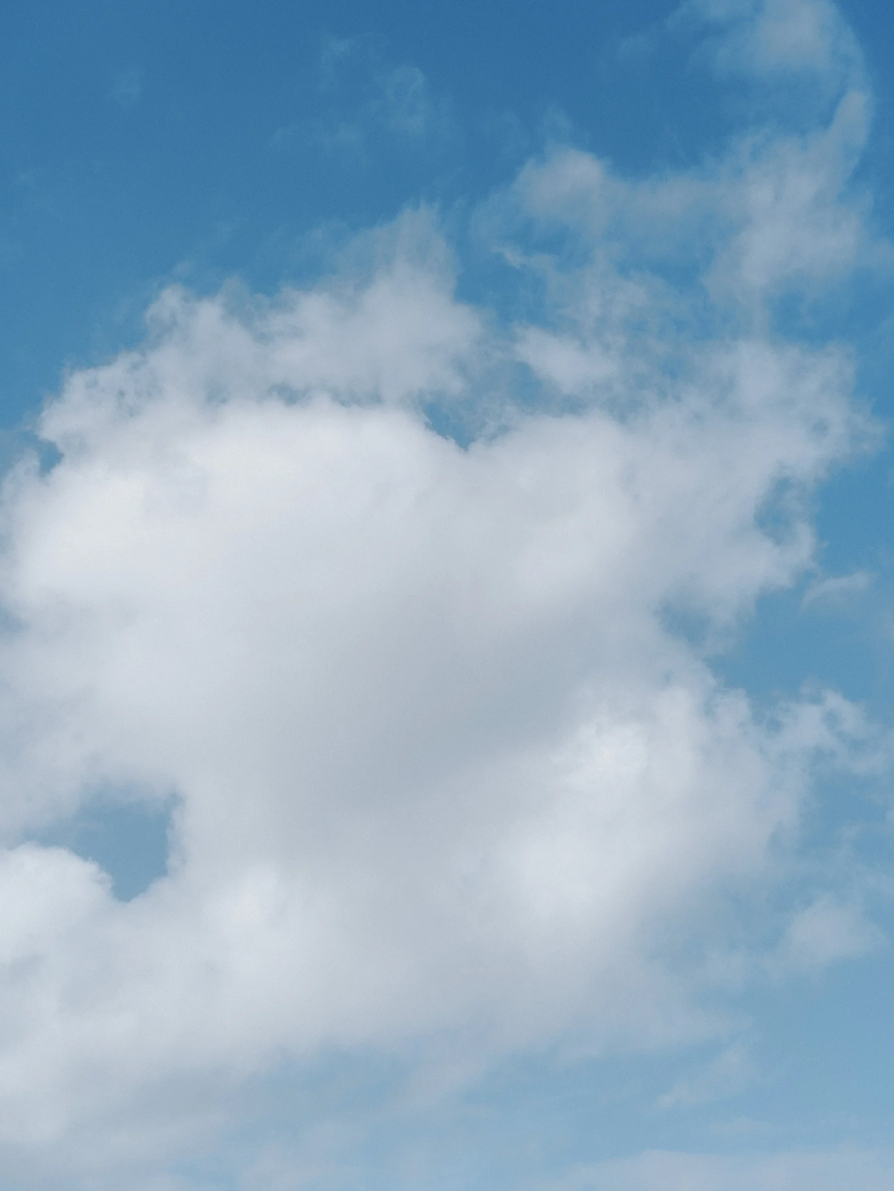 Blue sky with scattered white clouds.
