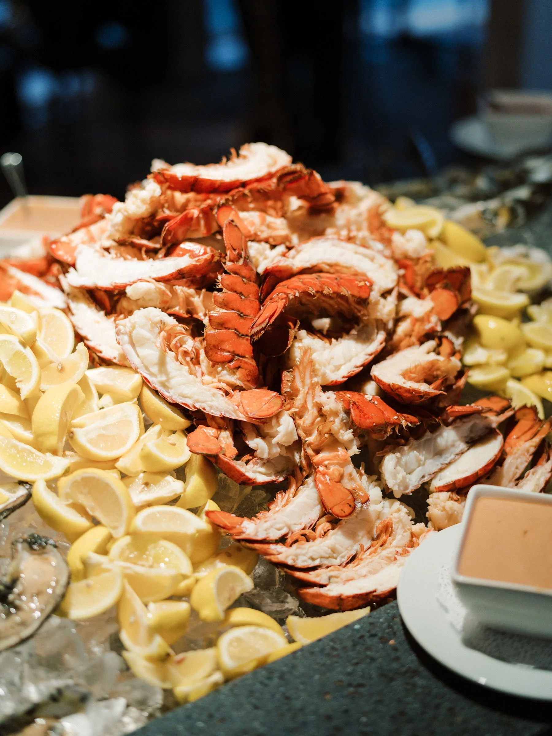 Crab shells and lemon wedges on ice at seafood buffet.