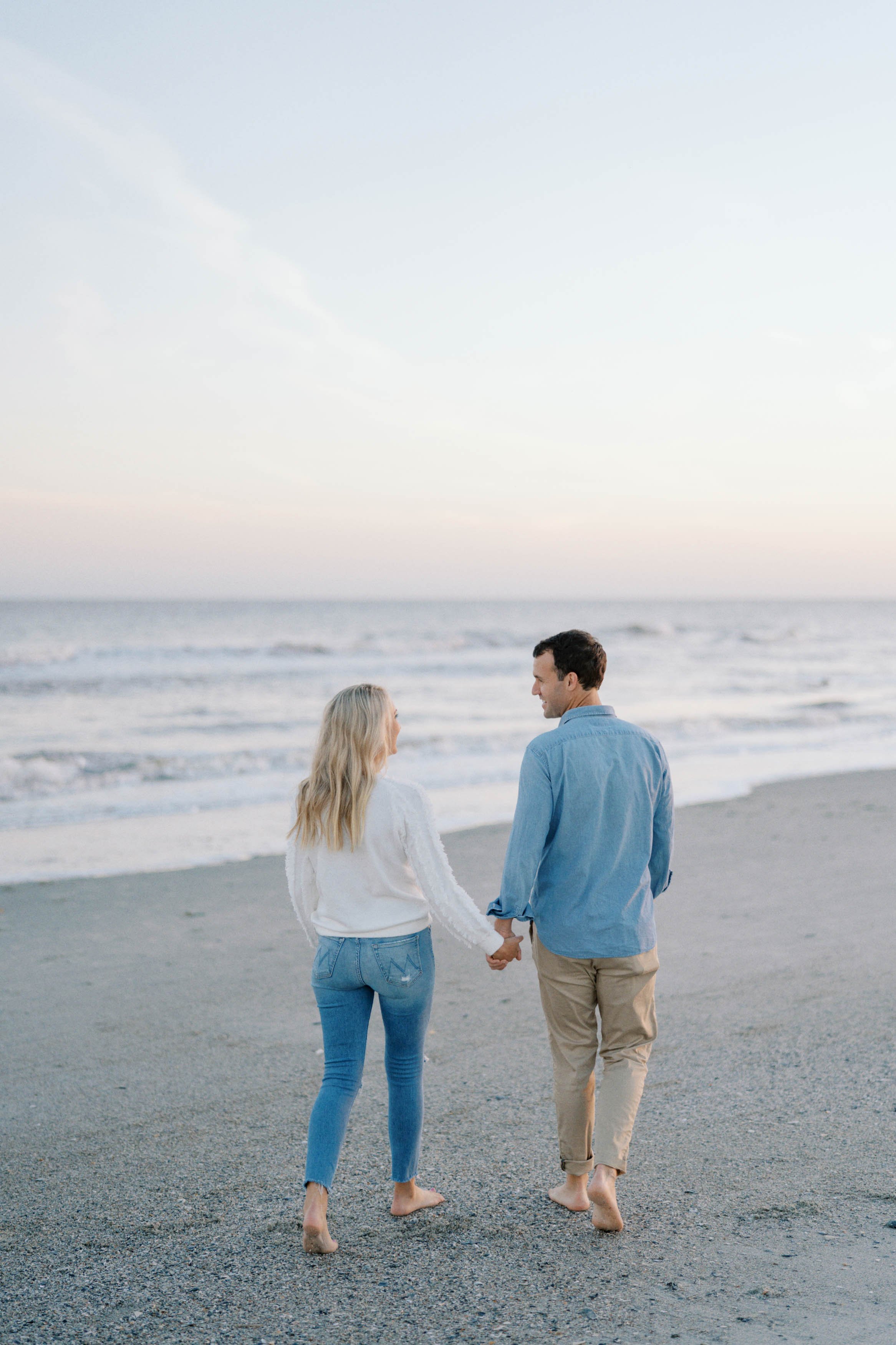 A couple, on Isle of Palms beach, walking hand-in-hand along the beach during sunset.