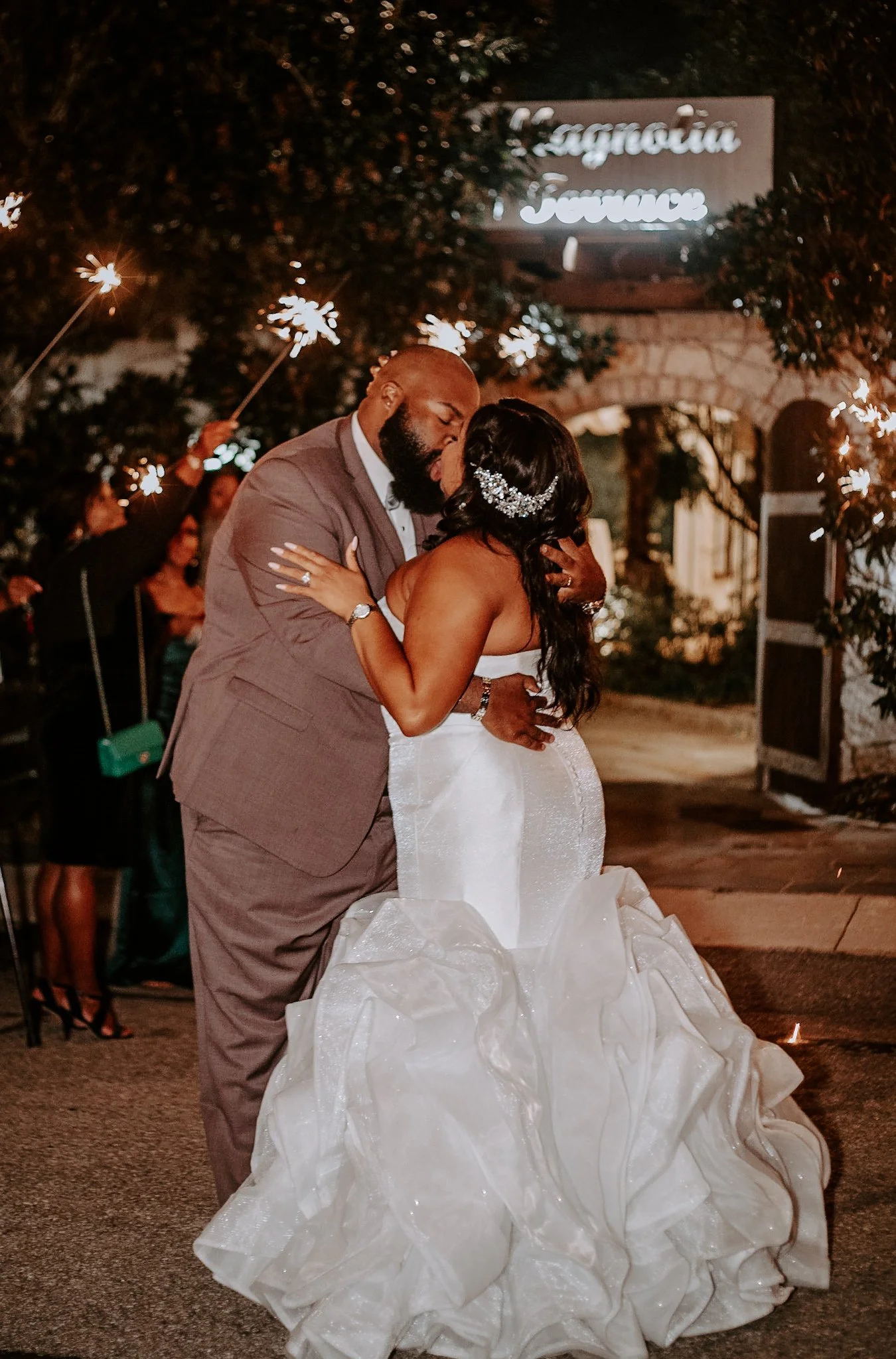 couple kissing among crowd on wedding exit