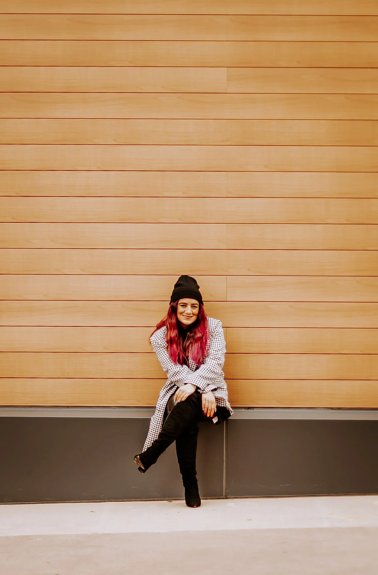 woman sitting on bench in front of orange wall