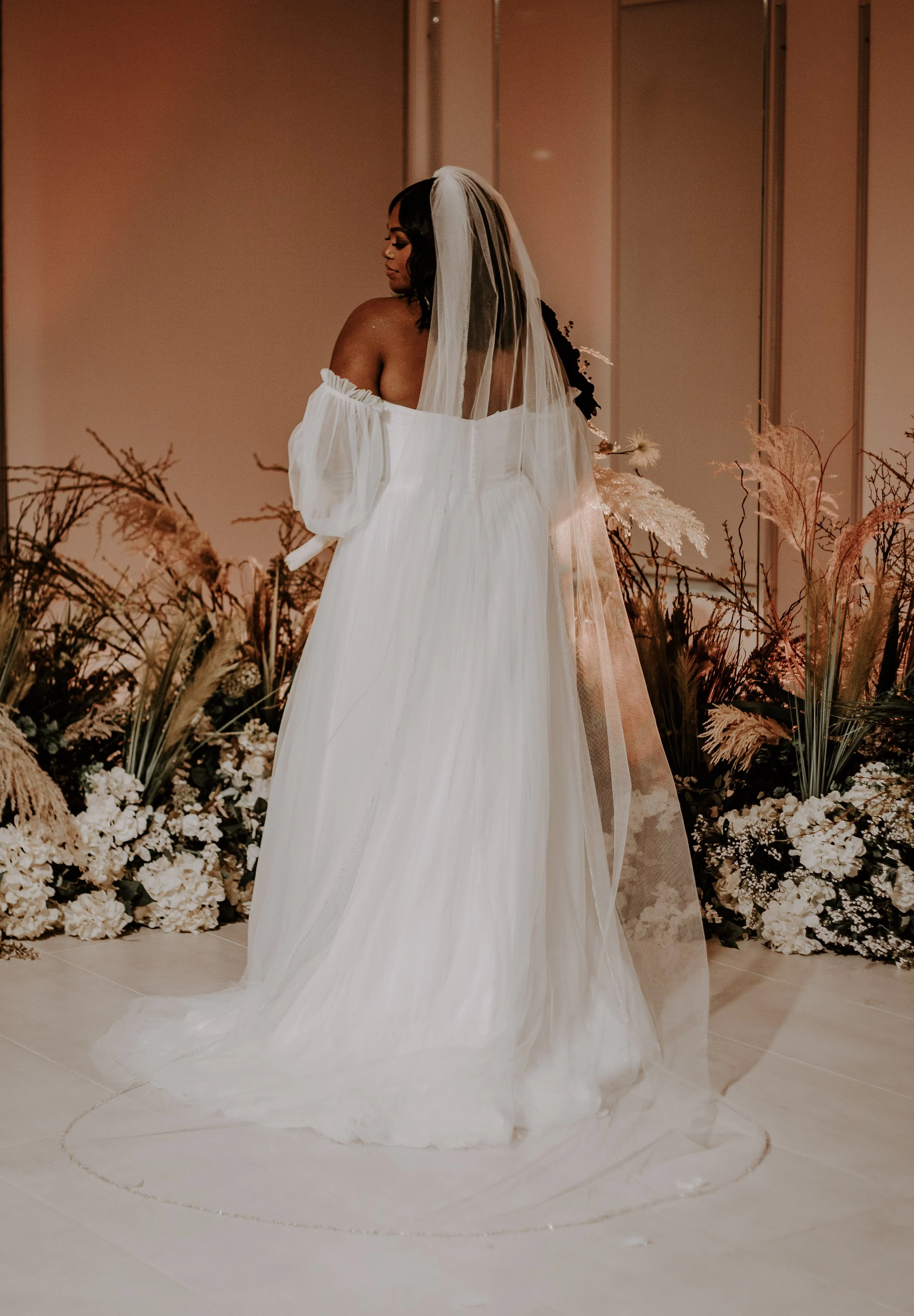 woman surrounded by flowers in wedding dress