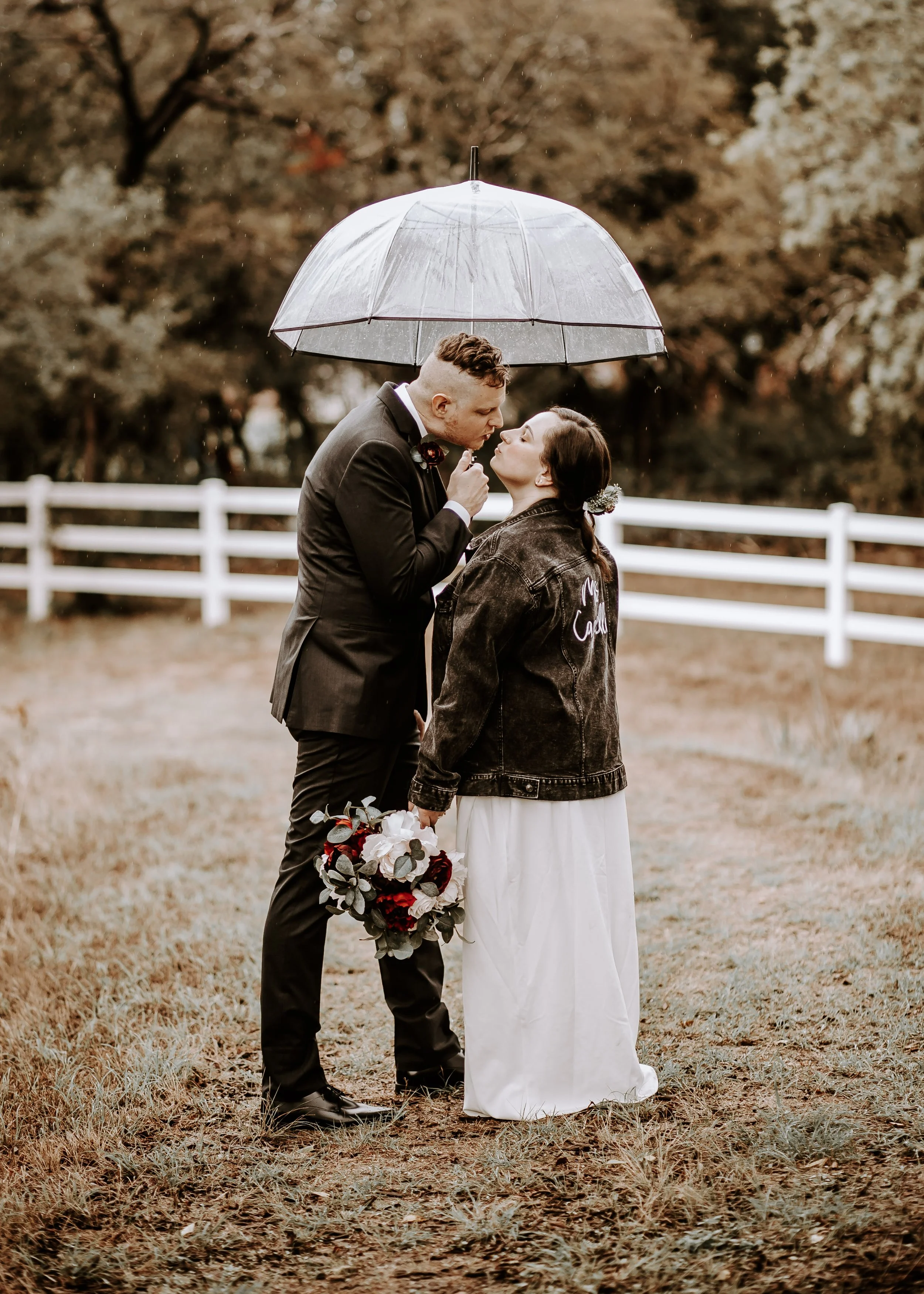 man and woman kiss under umbrella in rain