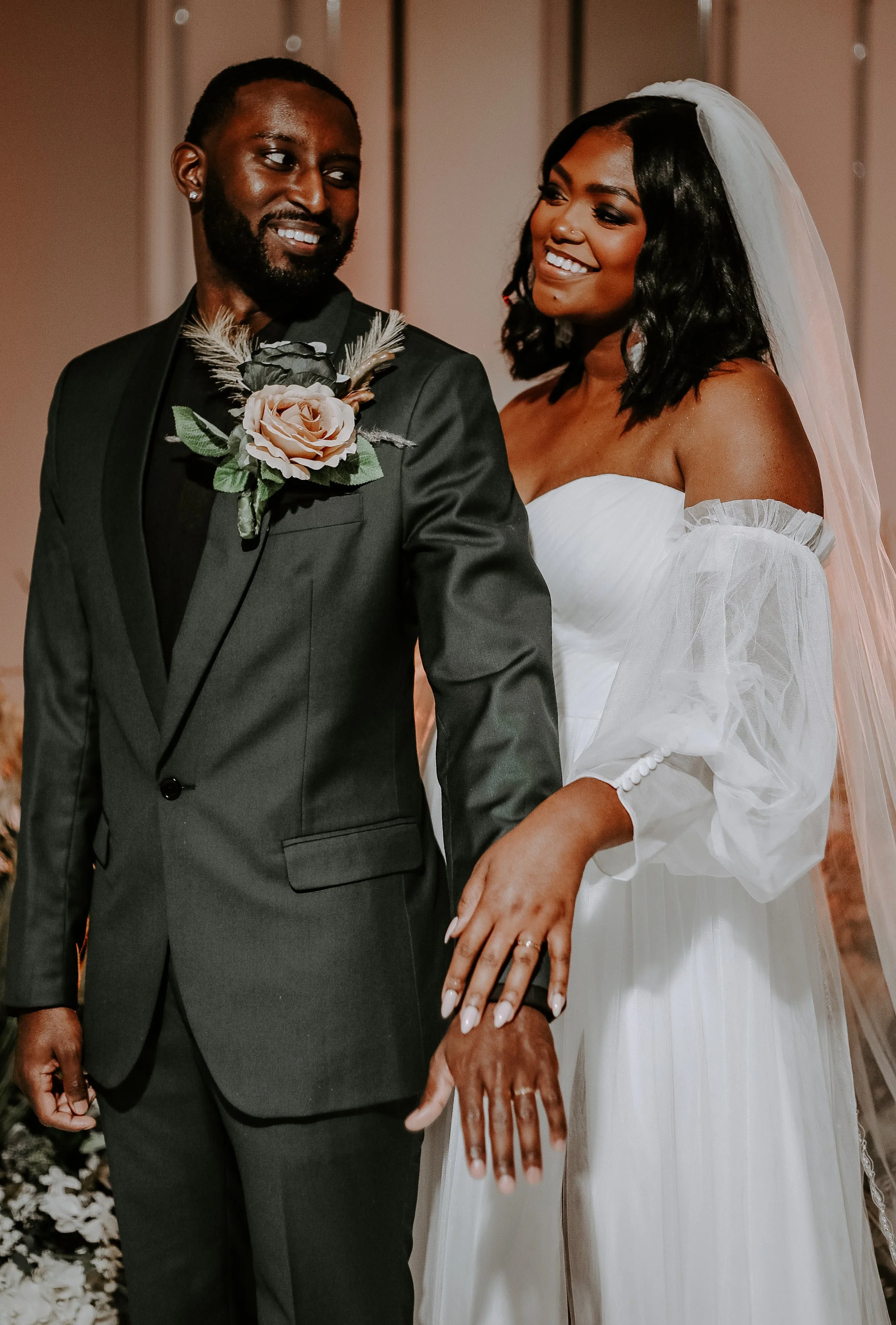 woman and man display rings while smiling at each other