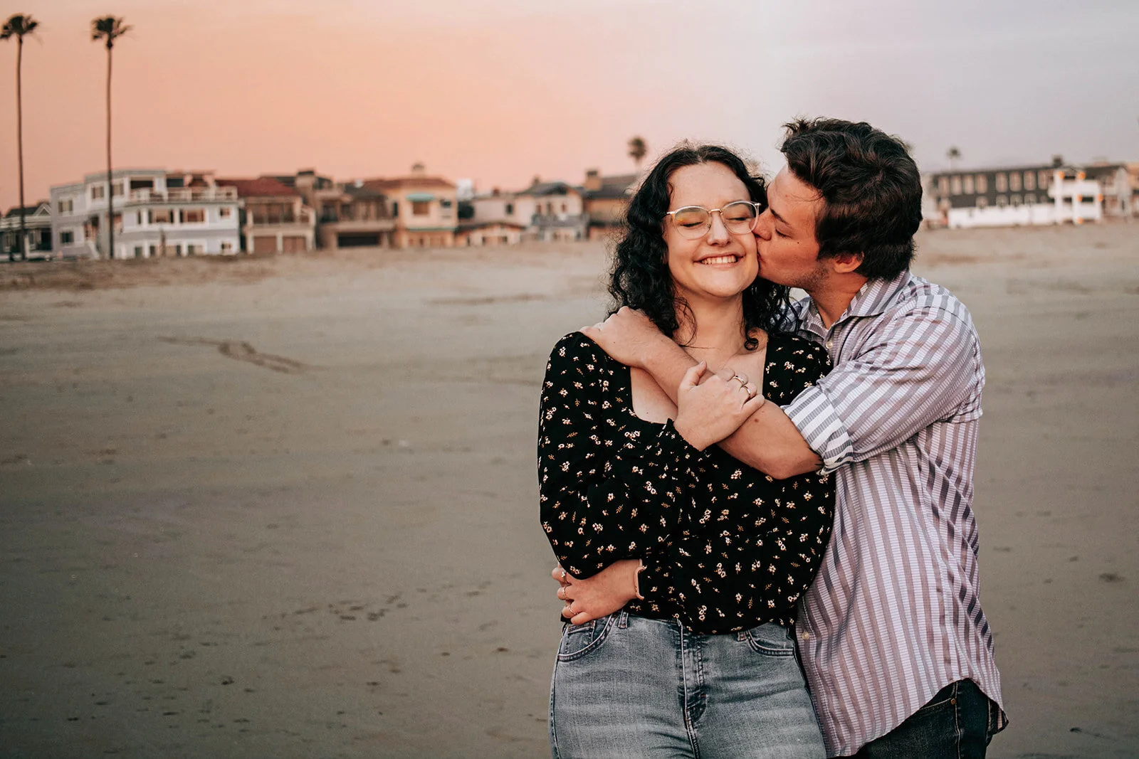 Couple kissing on the coast during an engagement photography session by Abigail Janelle Photography