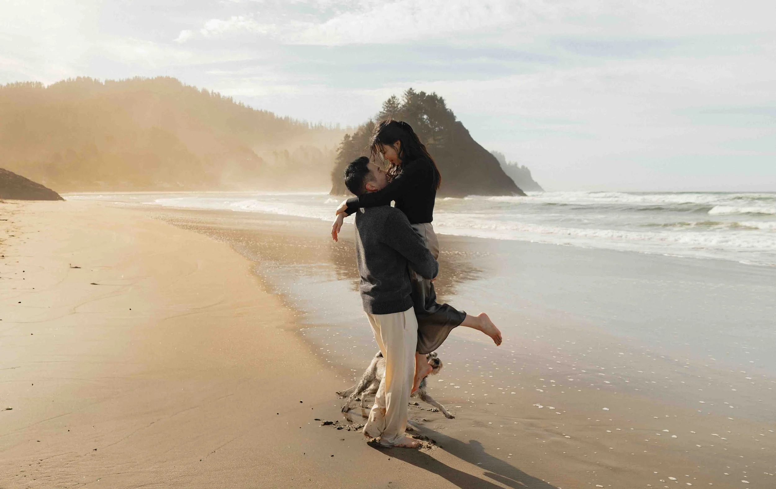 Engaged couple with their small dog on at Proposal Rock in Oregon