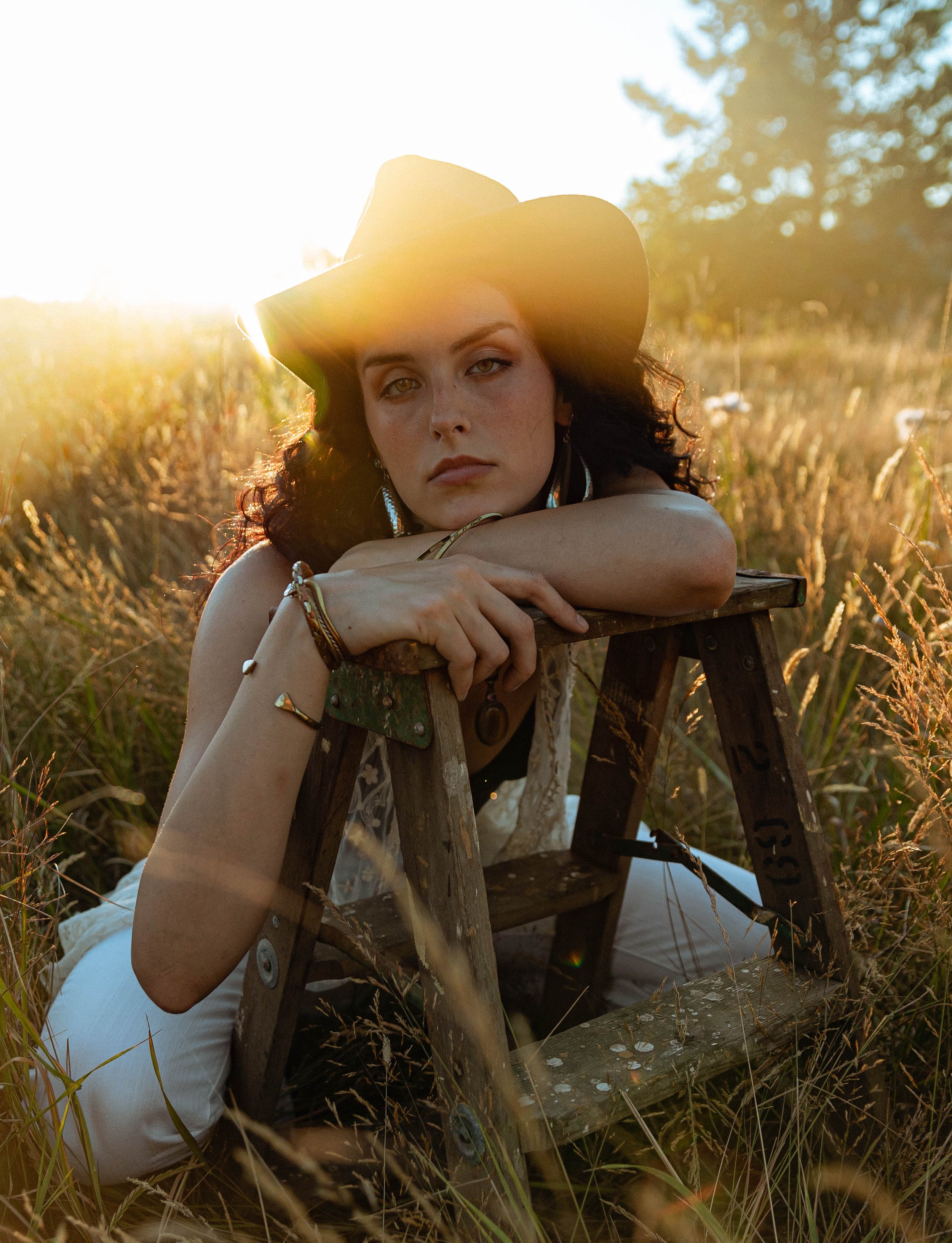Woman sitting in a field in Portland, Oregon enjoying the sunset by photographer Abigail Janelle Photography