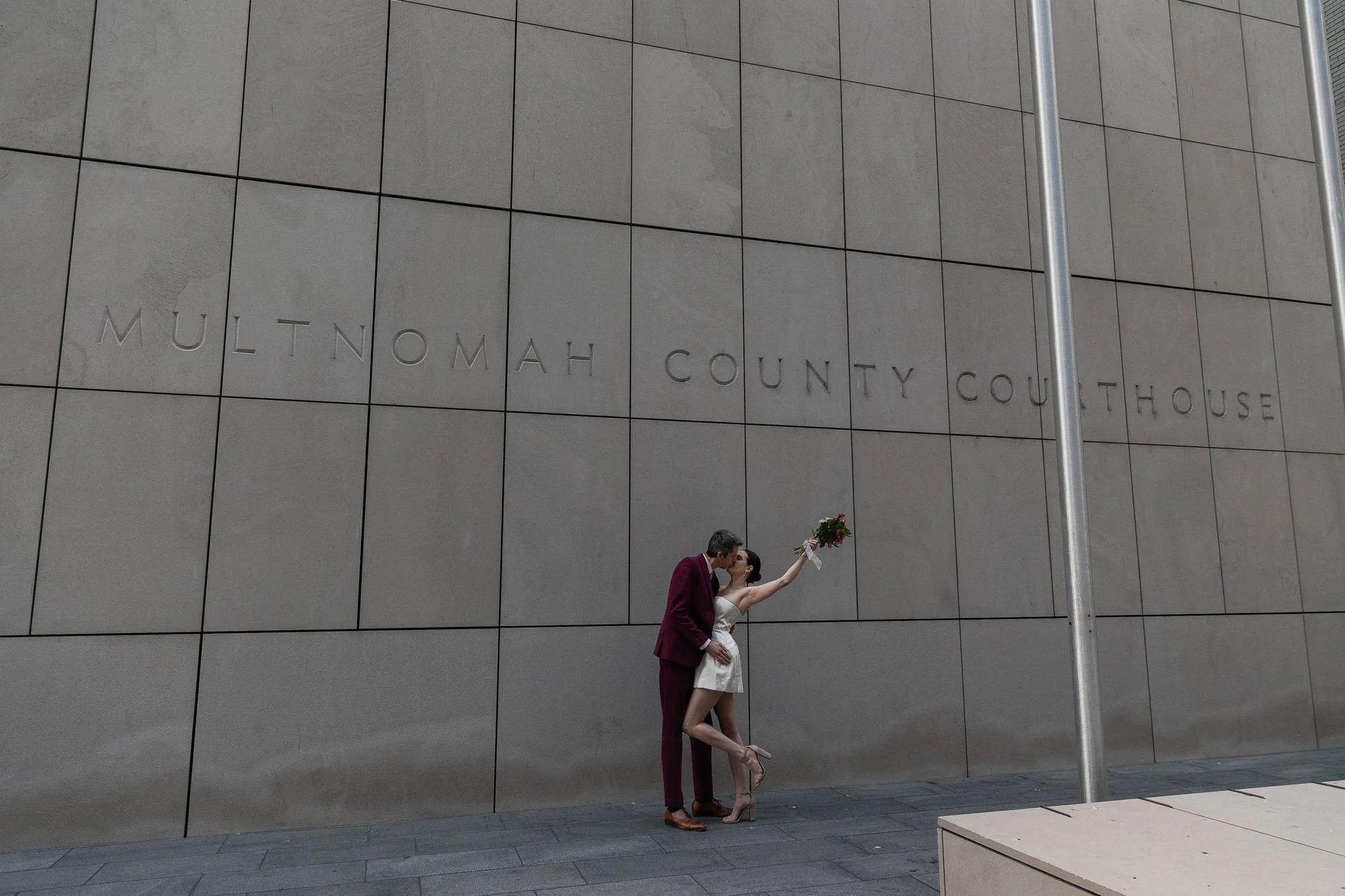 Couple celebrating their elopement outside of the multnomah county courthouse in downtown portland