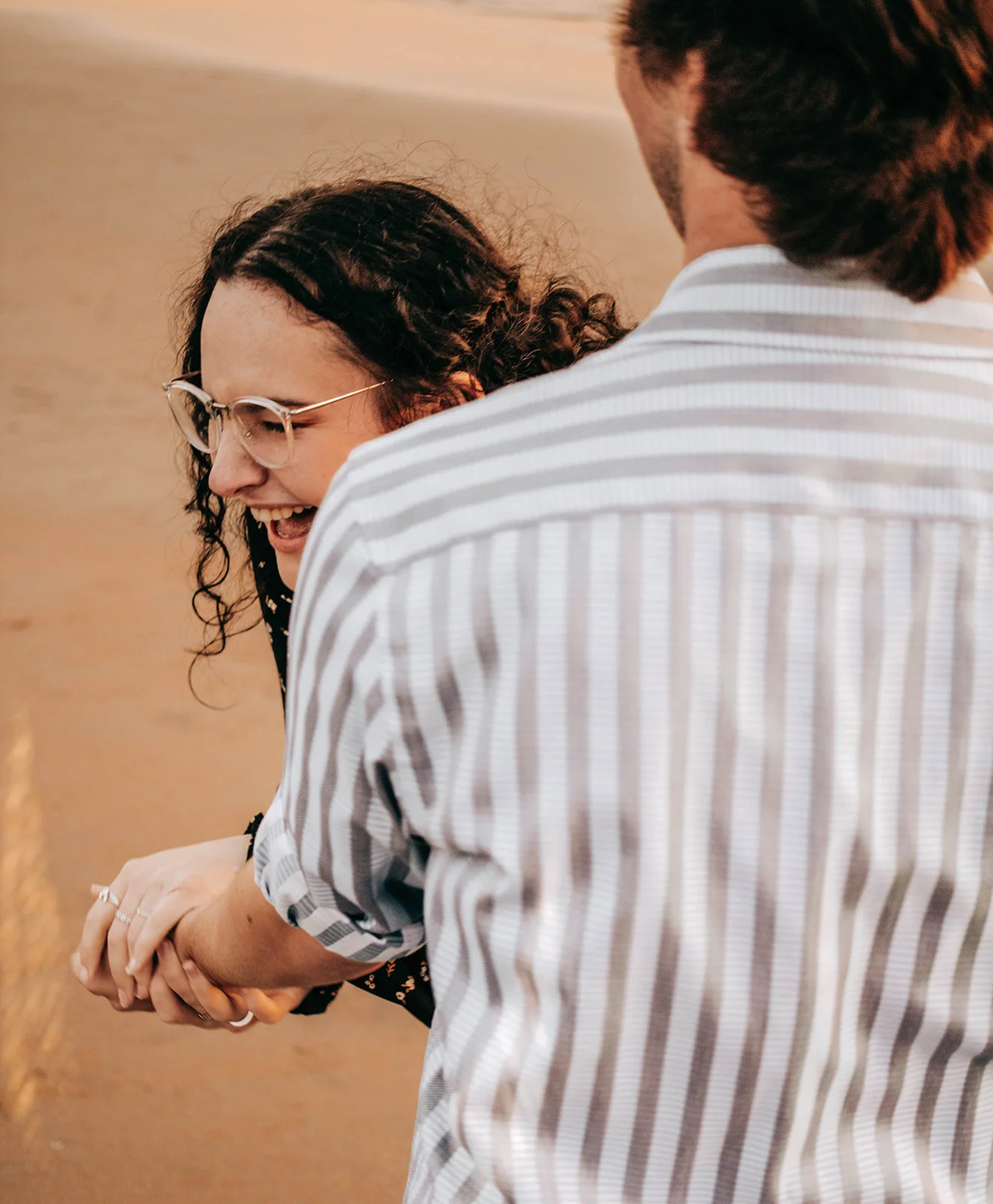 Couple laughing on the beach during an engagement session in Cannon Beach, Oregon