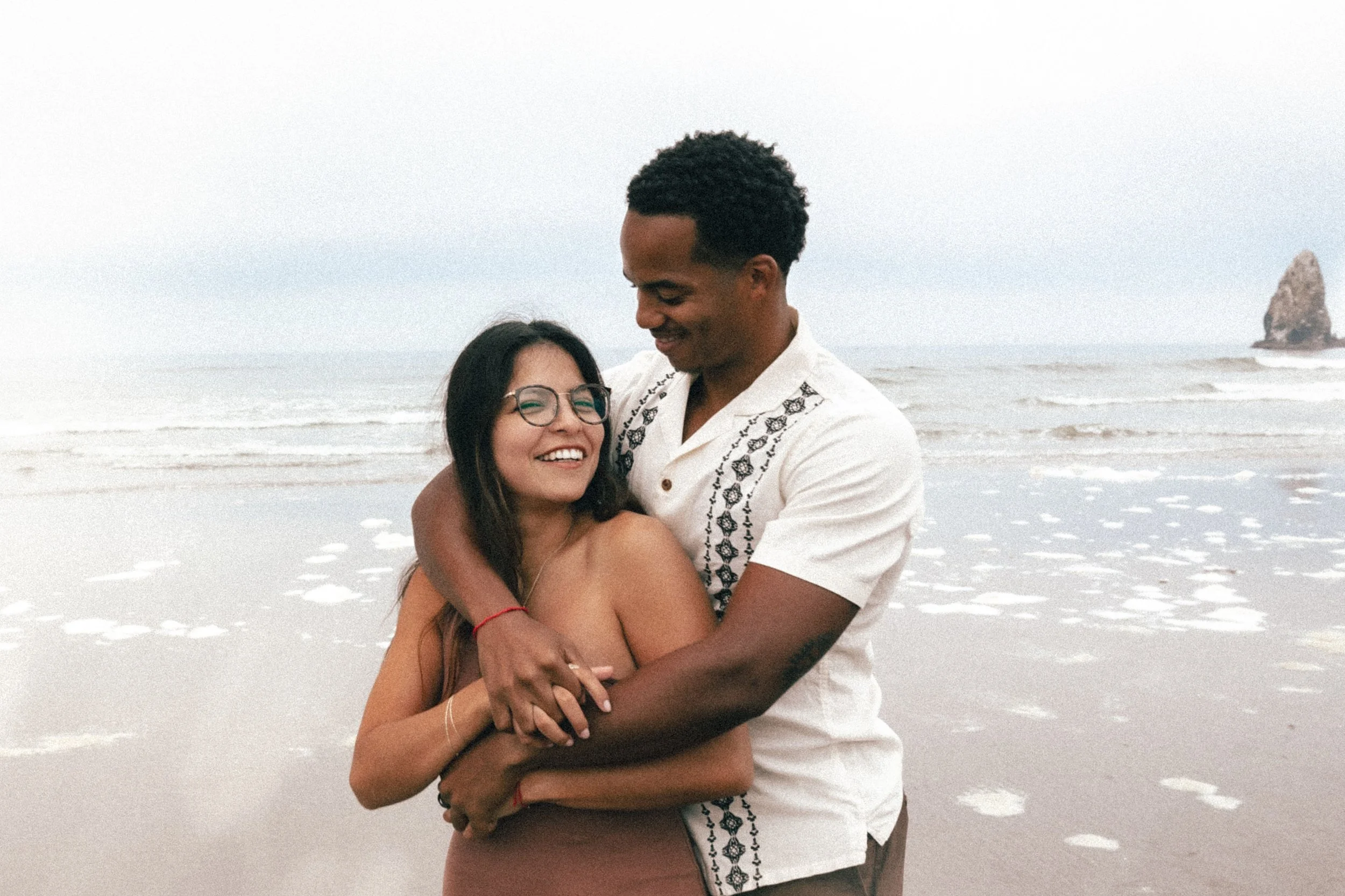 Couple smiling during Oregon Coast engagement session by Abigail Janelle Photography