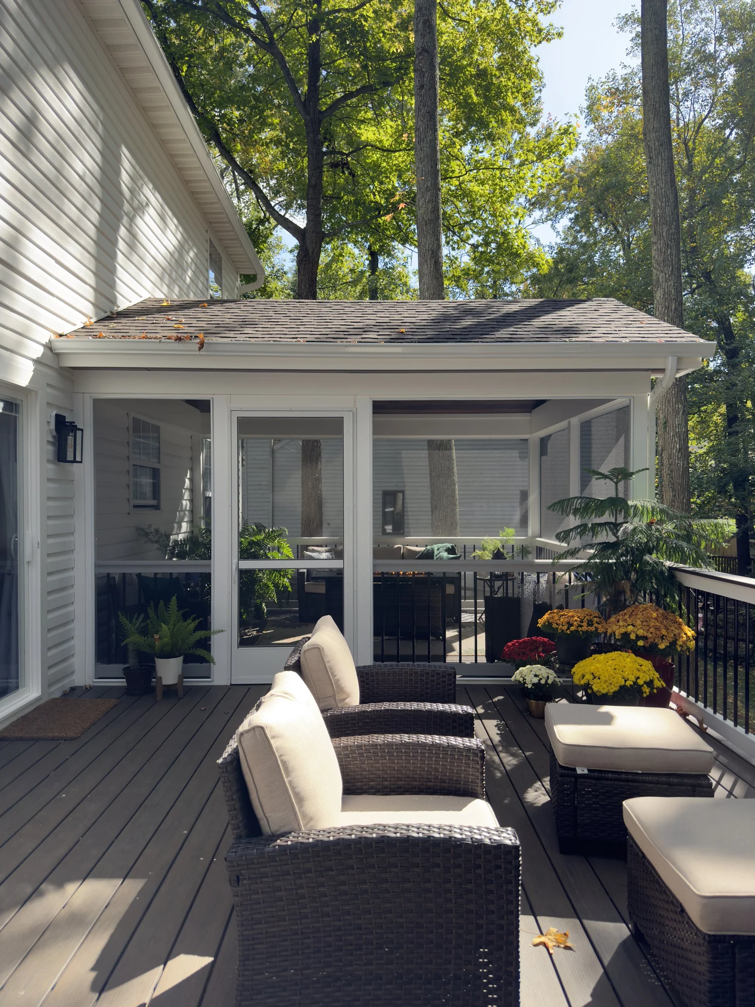 Composite deck surface with railing and wooded backyard view