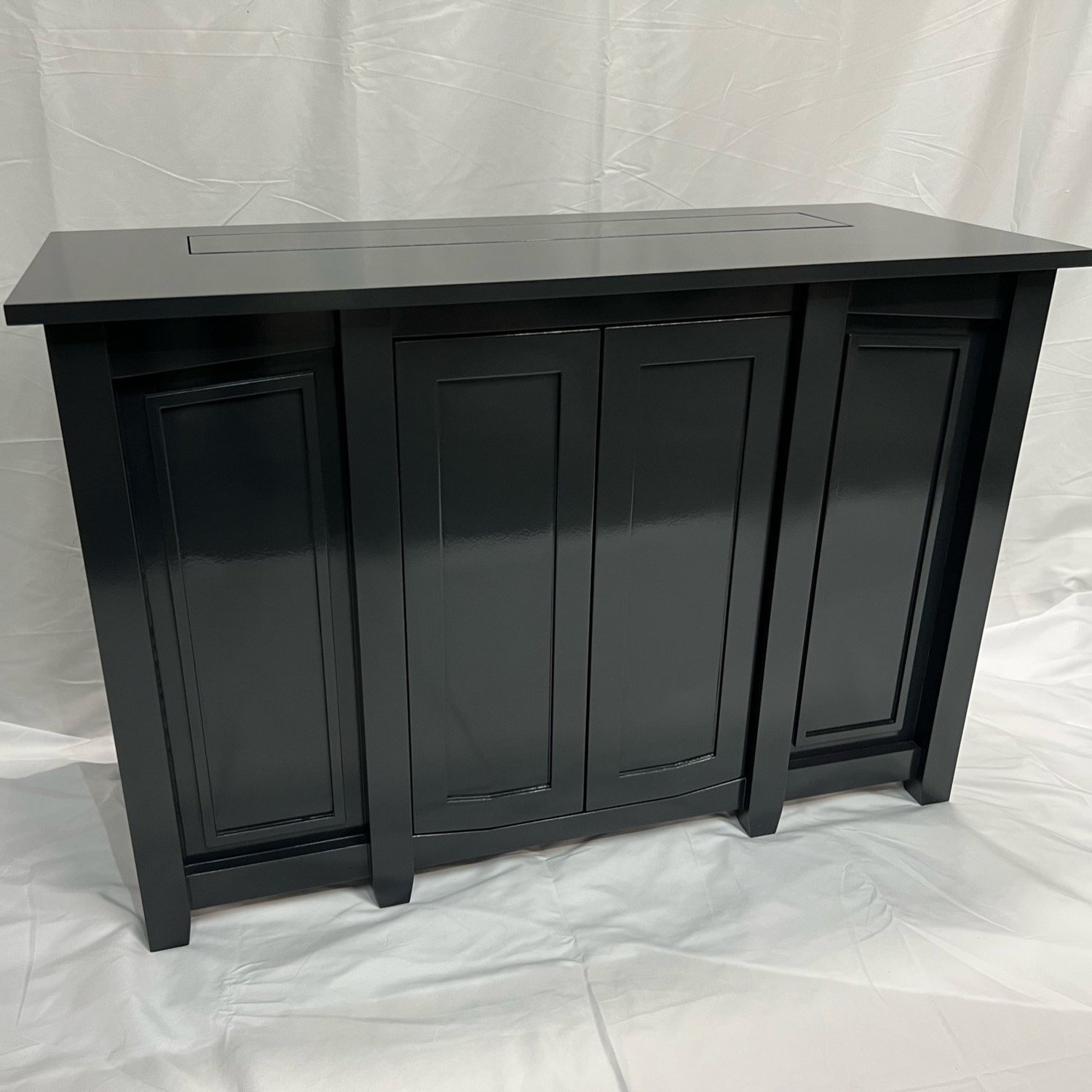 Custom black wood TV lift table with closed recessed panel doors