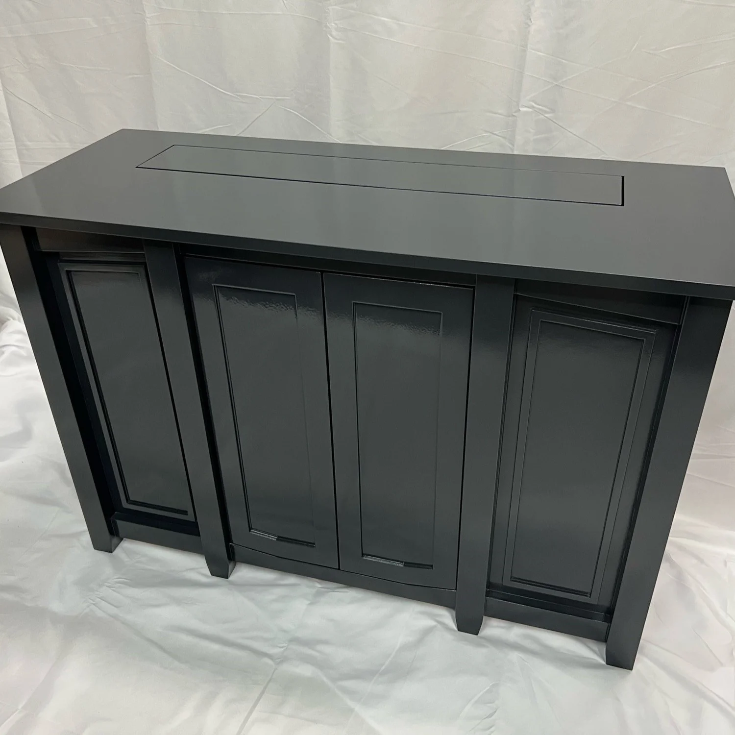 Fine carpentry detail on a custom black media cabinet