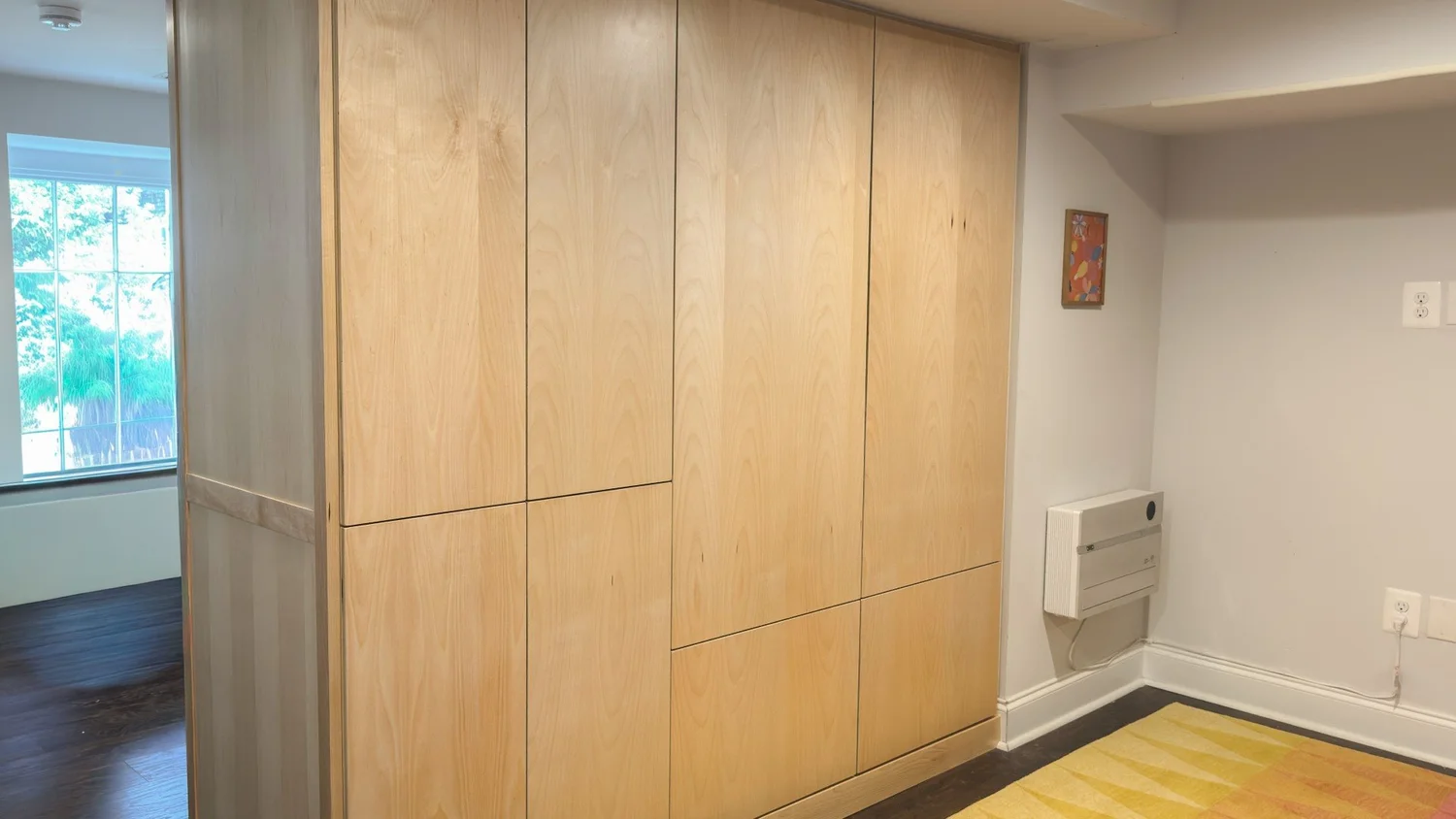 Side view of custom maple basement cabinet doors and surrounding trim