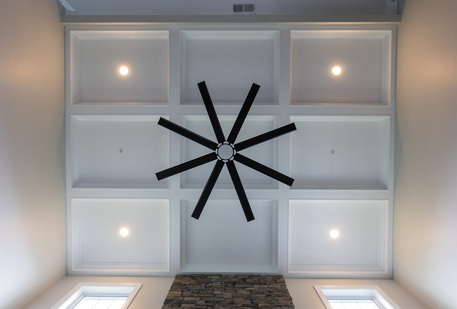 Two-story coffered ceiling with white moldings and a black ceiling fan in Baldwin Maryland