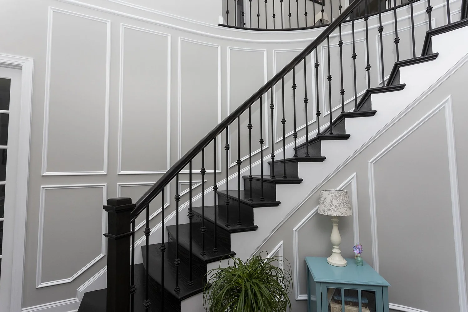 Curved foyer wall with finish carpentry leading toward a two-story living room