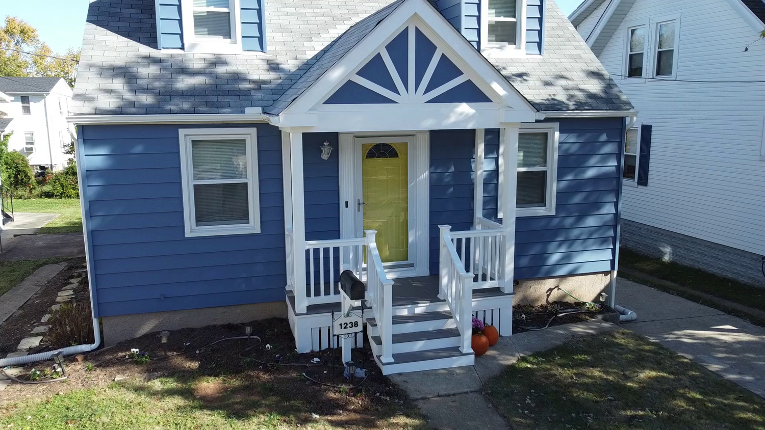 Composite stair treads and white railings on a front porch addition