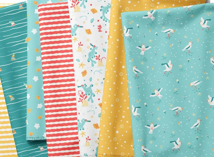 Various colorful fabrics with nautical and summer-themed patterns, including sea creatures, stripes, polka dots, and sailboats.