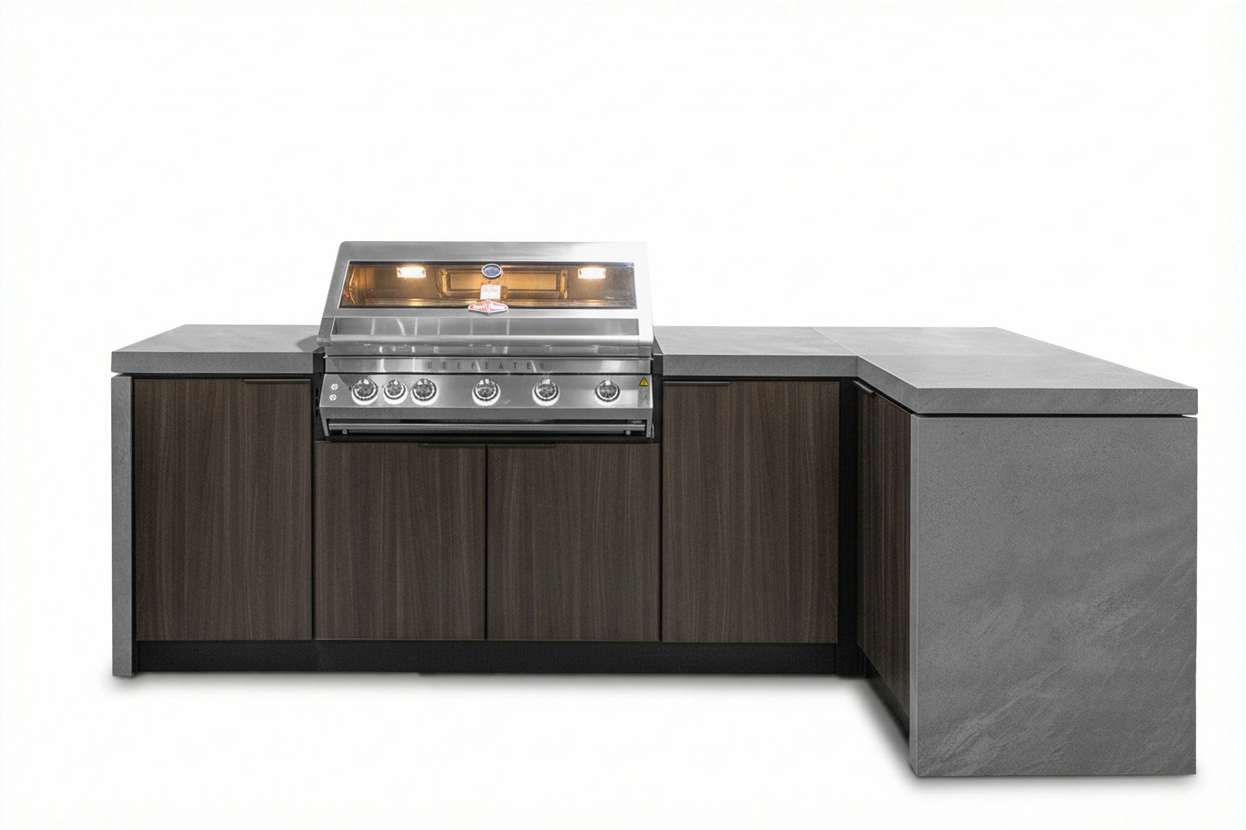 A stainless steel barbecue grill with a glass lid and control knobs, situated on a kitchen counter with dark wood cabinets underneath, against a plain white background.