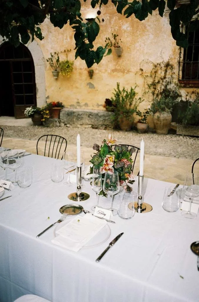 Long reception table styled with elegant floral compositions for Christie and Andrew's luxury wedding at Villa Almanita