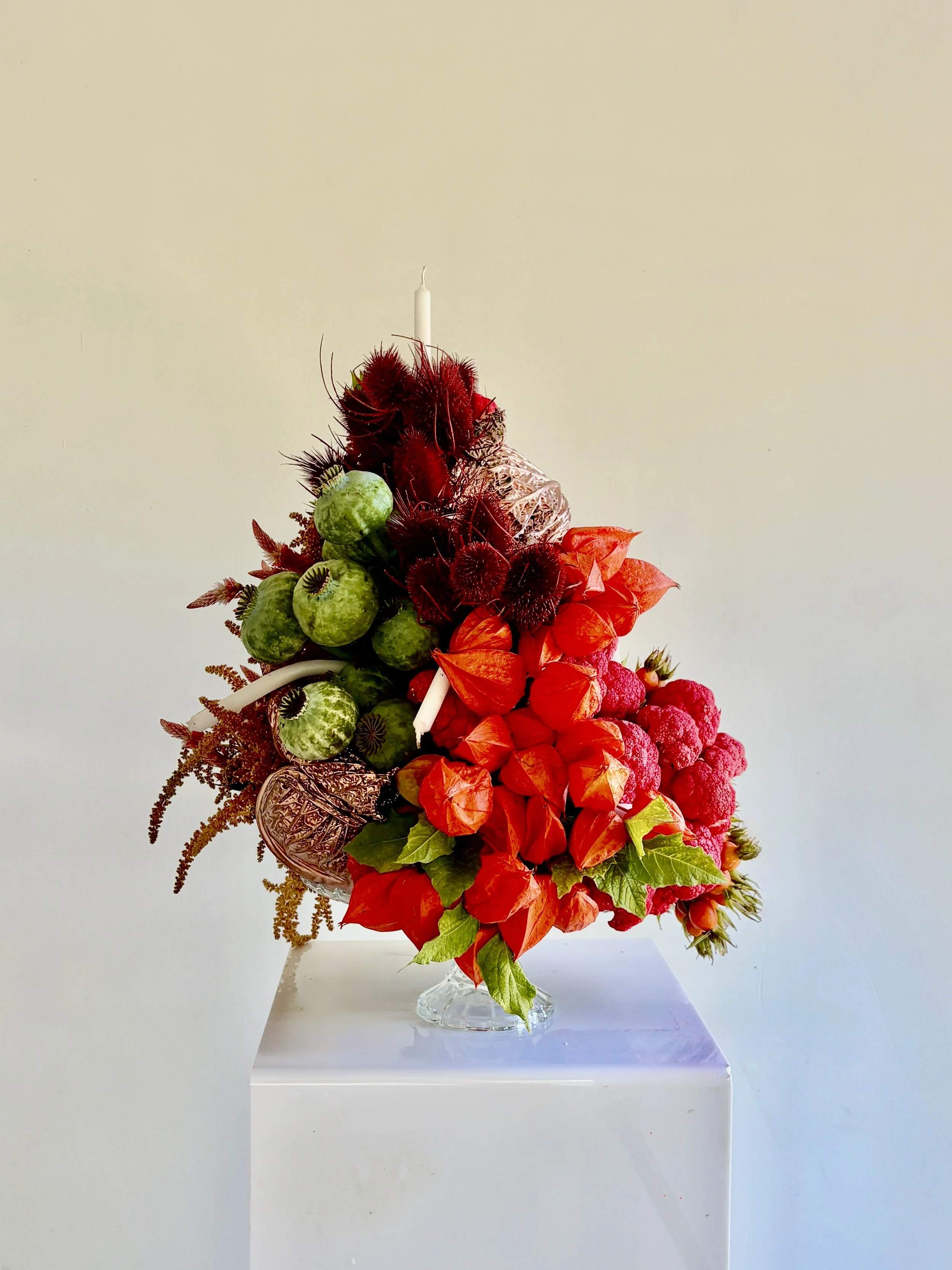 Creative floral design by Mosaic for designer Blanca Miró, presented as an unconventional birthday cake made from flowers, plants, fruit, vegetables and candles for a unique visual statement