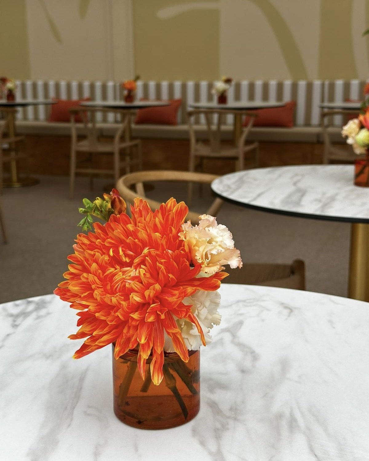 Artistic luxury floral arrangement with premium oversized blooms in a ceramic vase, designed for Amazon's hospitality venue at Cannes Lions Festival of Creativity and refreshed daily