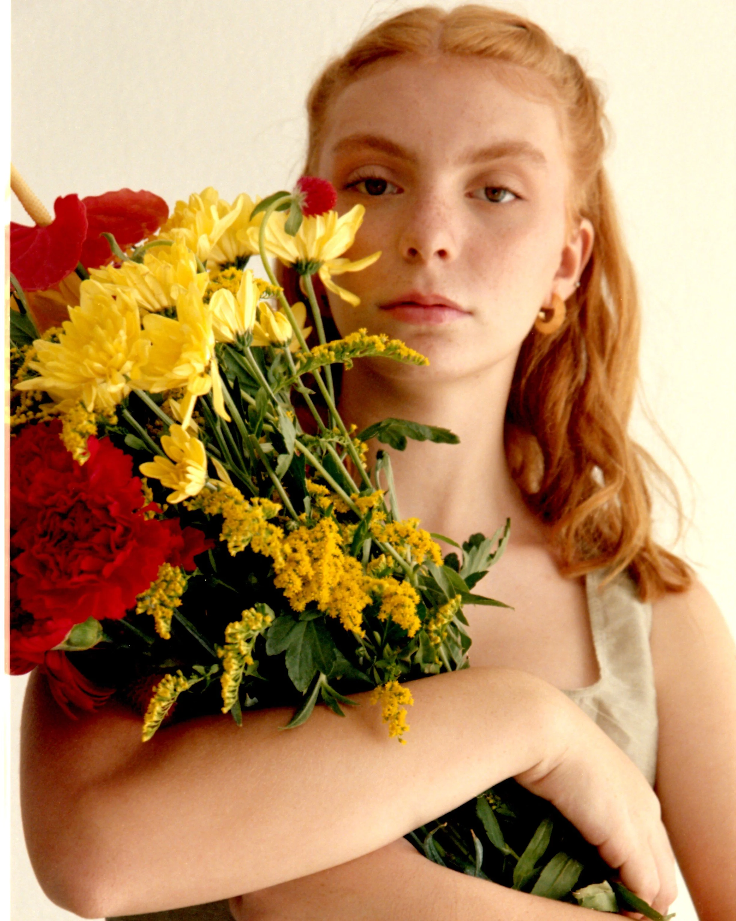 Editorial photoshoot in Barcelona featuring a model with a bouquet of yellow flowers, styled by Mosaic