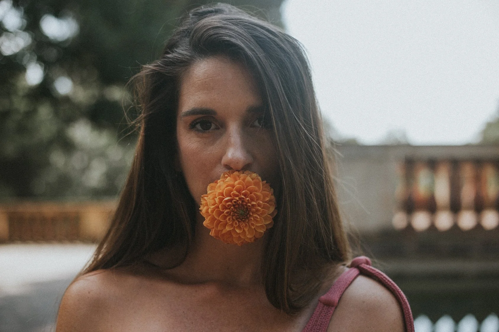 Editorial photoshoot with Mosaic Flowers in Horta park Barcelona, model with orange dahlia styled for international events